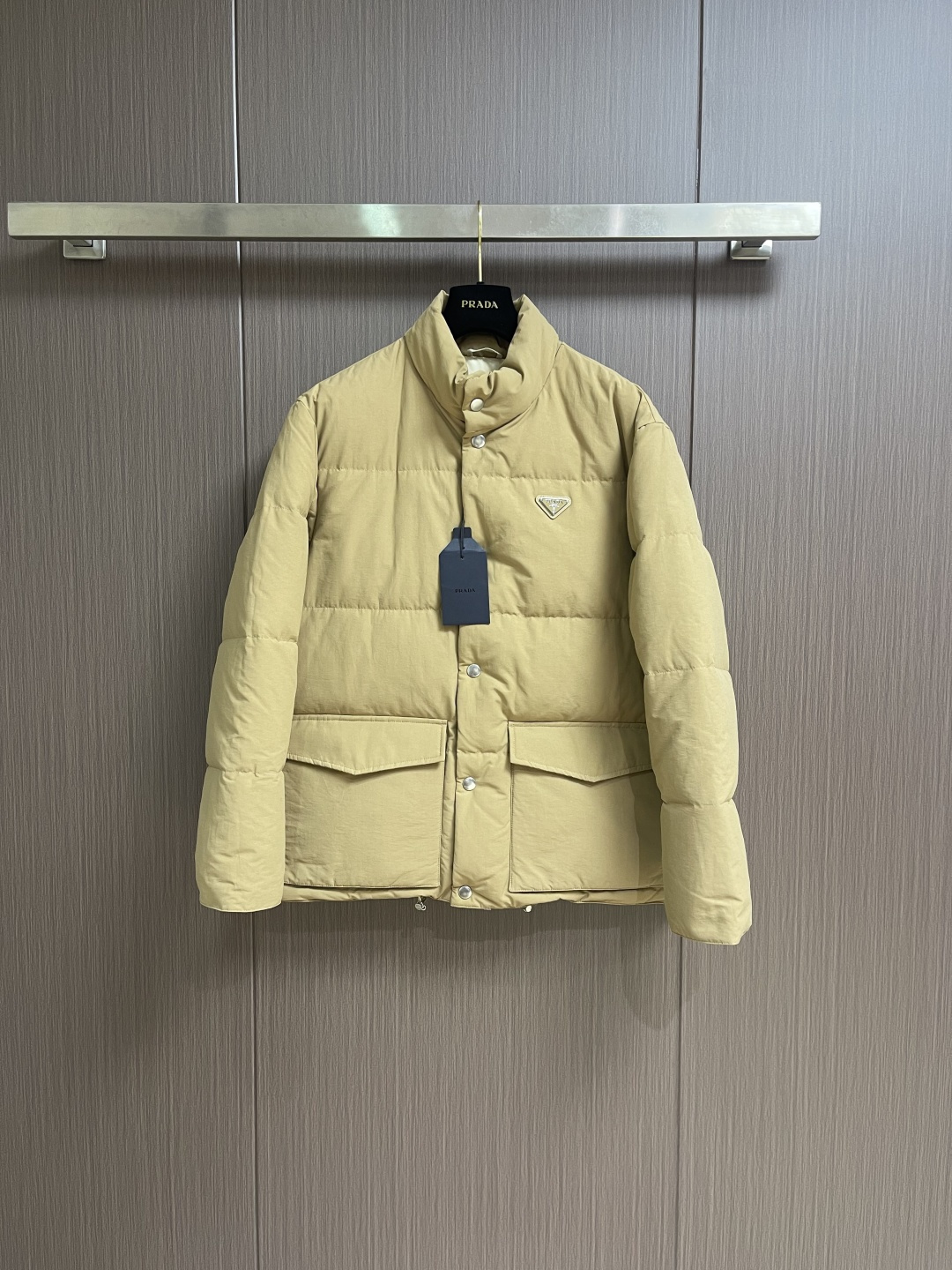 NO:624565,Prada 2025FW Down jacket with triangle logo on the chest. The fabric is made of ultra-fine nylon yarns woven in a high-density manner. The number of yarns per unit area is large, and the gaps between the yarns are very small, which can effectively block the penetration of cold wind. The fine weaving method keeps it lightweight and soft to the touch, and limits the lightness of the physical structure. The abundant down fiber is drilled out from the gap. The nylon fiber itself has good wear resistance and is not easy to snag, which significantly increases the service life and can easily meet the needs of multiple scenarios. The lining is made of high-density weaving of polyester fiber, with a thickness of 0.08mm to avoid increasing the overall weight and making it smooth to wear. The high-density weaving structure forms The wind resistance layer protects the thermal efficiency of the thermal insulation layer from loss, and can withstand the expansion pressure of down, preventing deformation and damage after long-term use. Buttons are custom-made rack-plated hardware buttons, selected from high-quality alloy metal, and each buckle is independently suspended. In carefully controlled current and solution, uniform coating is achieved at 360 degrees without dead ends. It has stronger wear resistance and corrosion resistance. It is filled with 90% of the new national standard white duck down, with a filling capacity of up to 280 grams. The down is full and fluffy, and has excellent temperature locking performance. It is light and has no weight, but can withstand the cold wind and make walking in winter as smooth as spring. Sizes S-XL, prada, jackets & coats,jackets & coats,down jacket,alexander wang19860909Prada 2025FW 胸前三角标识羽绒服外套夹克,面料选用极细锦纶纱线通过高密度的方式编织而成,单位面积内的纱线数量多,纱线之间的空隙非常小,能有效阻隔冷风穿透.细密的编织法使其保持轻量化和柔软的触感,在物理结构上限制了轻盈的羽绒纤维从缝隙中钻出.锦纶纤维本身拥有良好的耐磨性,不易勾丝,显著提升了使用年限,轻松应对多场景需求.里布采用聚酯纤维高密编织而成的里布,0.08mm厚度避免增加整体重量且穿着顺滑,高密编织结构形成风阻层,保护保暖层热效率不流失,同时可承受羽绒膨胀压力,防止长期使用后变形破损.扣子定制挂镀五金扣子,精选高品质合金金属,每一枚扣饰都被独立悬挂,在精心控制的电流与溶液中,实现360度无死角的均匀镀层,具有更强的耐磨性与搞腐蚀能力.内里严选90％新国标白鸭绒填充,充绒量高达280克,绒朵饱满蓬松,锁温性能出众.轻盈无负重感,却可抵御凛冽寒风,让冬日行自如如春.尺码S-XL,,prada,jackets & coats,jackets & coats,down jacket,alexander wang,Men's clothing