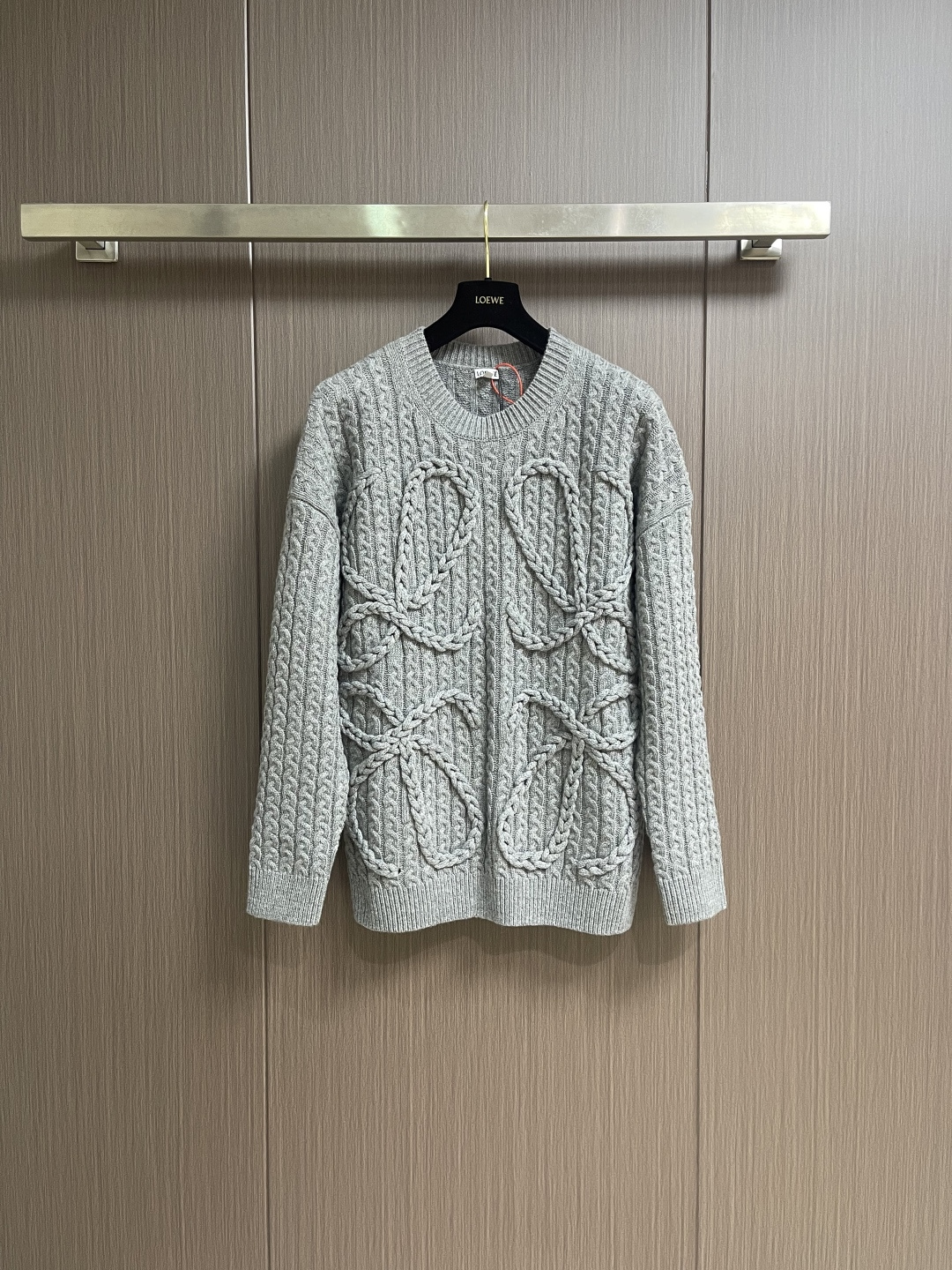 NO:627697,Loewe Anagram twist knitted sweater, custom-woven and dyed heavy mercerized wool embossed knitted wool, the iconic woven Loewe Anagram logo is embellished on the front, and the design of dropped shoulders subtly weakens the toughness of the shoulders and makes the body shape more soft. The hand-operated special machine embossed pattern technology is manually controlled by the craftsman to customize the special knitting machine. The knitting logic of human-machine collaboration adjusts the yarn tension in real time and controls the rise and fall of the knitting needles, forming a Loewe with a three-dimensional concave and convex texture.  Anagram pattern. Composite dual craftsmanship of global twisted rope braiding, a symphonic weaving technique of hand and machine. The entire garment is made of twisted rope + webbing composite weaving. It is hand-connected row by row. Each row needs to complete the three steps of twisting the rope, inserting the webbing and resetting the needle bar. It takes 200-300 rows to knit a garment (time-consuming, labor-intensive and expensive). Sizes S-XL, loewe, sweaters, alexander wang19860909Loewe Anagram 麻花编织毛衣,定织定染重磅丝光羊毛浮雕针织毛料,标志性编织Loewe Anagram徽标点缀于正面,落肩的设计巧妙地弱化了肩部的硬朗感,让身形更显柔和.手摇专机浮雕花型工艺,通过匠人手工操控定制化专用编织机,人机协同的编织逻辑,实时调整纱线张力,控制织针起落,形成具有立体凹凸肌理的Loewe Anagram花型图案.全域扭绳编织带复合双工艺,手工与机械的交响织艺,整件服饰均采用扭绳＋织带复合编织 逐行手工衔接,每编织1行需完成扭绳缠绕一织带穿插一针床复位3个步骤,编织一件成衣需累计200-300行（耗时耗力 工价昂贵） 尺码S-XL,,loewe,sweaters,alexander wang,Men's clothing