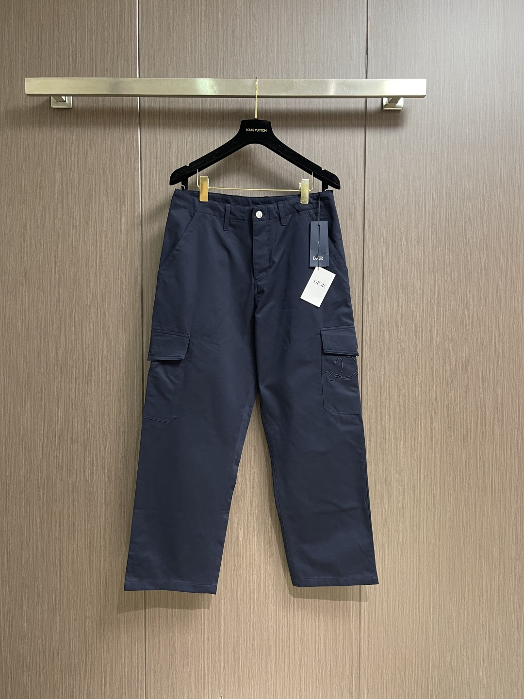 NO:661025,Dior  Cotton Gadani overalls. The fabric has been enzyme washed and pre-shrunk to form a crisp and soft texture that is wrinkle-resistant and wear-resistant. The utility pockets on both sides of the trousers are designed with three-dimensional patch pockets. The pockets are equipped with metal zippers. The zipper teeth are electroplated and polished to make them smooth and easy to pull and not easy to oxidize. The bag body is reinforced with double stitching to increase the load-bearing capacity. The waist is equipped with a belt loop and an adjustable buckle design. The belt loop is  The same fabric hemming process, the buckle is made of alloy material with matte sandblasting treatment, and the texture is high-end. The crotch adopts classic cross-reinforced stitching, the trousers are hemmed and seamed, and the overall cut is a straight silhouette. Each splicing is accurately patterned and aligned, and the stitching is neat and detailed, perfectly integrating the practicality of workwear with the craftsmanship aesthetics of Dior's advanced men's wear. The overall routing is straight and delicate, the fabric is comfortable and soft, and the colors are consistent and without color difference.  It can be matched with the same style to create a fashionable look, and can be used in various occasions. Customized accessories, complete with three standards, same style for men and women!  Size 46-48-50-52-54-56 46 yards waist 78 hips 104 pants length 101 48 yards waist 82 hips 108 pants length 103 50 yards waist 86 hips 112 pants length 105 52 yards waist 90 hips 116 pants length 107 54 yards waist 94 hips 120 pants length 109  Size 56, waist 98, hips 124, pants length 111, dior, dior,  19860909Dior 棉布华达尼工装裤,面料经酵素洗与预缩水处理,形成挺括且柔软的质感,同时具备抗皱耐磨的特性.裤身两侧工装口袋采用立体贴袋设计,袋口配备金属拉链,拉链齿经电镀抛光工艺处理,顺滑易拉且不易氧化,袋身以双道车线加固,提升承重力.腰部搭载腰带环与可调节卡扣设计,腰带环为同面料包边工艺,卡扣选用合金材质经哑光喷砂处理,质感高级.裆部采用经典的十字加固车线,裤脚为折边锁边工艺,整体剪裁为直筒廓形,每一处拼接都经过精准打版对位,缝线工整细密,完美融合工装实用性与迪奥高级男装的工艺美学.整体走线平直细腻,面料舒适柔软,颜色一致无色差 能与同款搭配营造时尚造型,驾驭各种场合,定制辅料,三标齐全,男女同款！尺码46-48-50-52-54-56 46码 腰围78臀围104 裤长101 48码 腰围82臀围108 裤长103 50码 腰围86臀围112裤长105 52码 腰围90臀围116裤长107 54码 腰围94臀围120裤长109 56码 腰围98臀围124裤长111,,dior,dior, ,Men's clothing