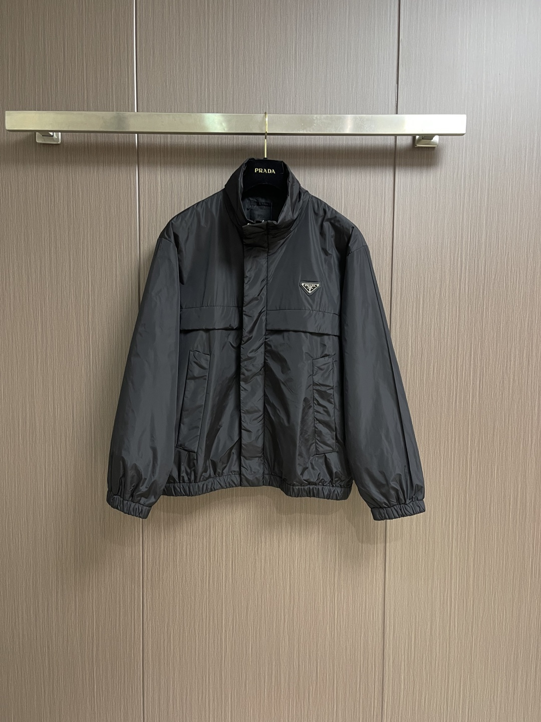 NO:661006,Prada triangle logo lightweight stand-collar jacket, this long-sleeved jacket is made from LIFESTYLE  UMACARTA paper-feel nylon, ultra-light regenerated nylon high-quality fabric, is as light as paper. The slightly wrinkled appearance of the fabric is reminiscent of the texture of paper. The upper body is comfortable to wear and feels smooth, and its windproof performance is also excellent. The left chest of the front panel is decorated with the iconic enamel-coated metal triangle  The angular logo is made of metal with clear patterns and texture, the font is smooth and textured, and the details highlight the brand style. The position of the pocket is carefully designed to facilitate carrying items without affecting the overall shape, which is both practical and beautiful. The silhouette is tailored and the upper body is comfortable  , freedom of movement, and meticulous workmanship. The zipper opening and closing design is paired with a concealed button placket. The opening size of the jacket can be adjusted according to the needs of the outfit, making it easy to put on and take off. There are elastic drawstrings at the cuffs and hem, which can effectively prevent cold wind from blowing back. The classic stand-up collar design is handsome and stylish. This jacket is simple  It has always been a must-have item for outdoor sports and travel. It is not only lightweight and durable, but also classic and versatile, completing a low-key and high-end fashion wear. It combines minimalist aesthetics and functionality, and has a high degree of adaptability. Sizes S-XL, prada, cartier, jackets  & coats,jackets & coats, 19860909Prada 三角徽标轻薄立领夹克外套,这款长袖外套取材于LIFESTYLE UMACARTA纸感尼龙,超轻再生尼龙优质面料,轻如纸张.面料略有皱褶的外观,让人想起纸张的质感.上身穿着舒适,手感顺滑,它的防风性能也非常出色.前幅左胸处饰以标志性的涂珐琅金属三角形徽标,由金属制成图案纹路清晰明了,字体流畅有质感,细节之处彰显品牌格调.口袋的位置经过精心设计,方便携带物品的同时也不会影响整体造型,兼具实用性与美观性.廓形版型剪裁,上身舒适,活动自如,做工细致到位.拉链开合设计搭配暗扣门襟,可根据穿搭需求调节夹克的开口大小,穿脱方便.袖口和下摆处分别设有弹力束绳,能有效防止冷风倒灌.经典立领设计,帅气有型.这款夹克简直是户外运动、出游的必入好物,不仅轻量耐用,还经典百搭,完成低调高级的时尚穿搭.将极简美学和功能性结合于一身,适配度很高.尺码S-XL,,prada,cartier,jackets & coats,jackets & coats, ,Men's clothing