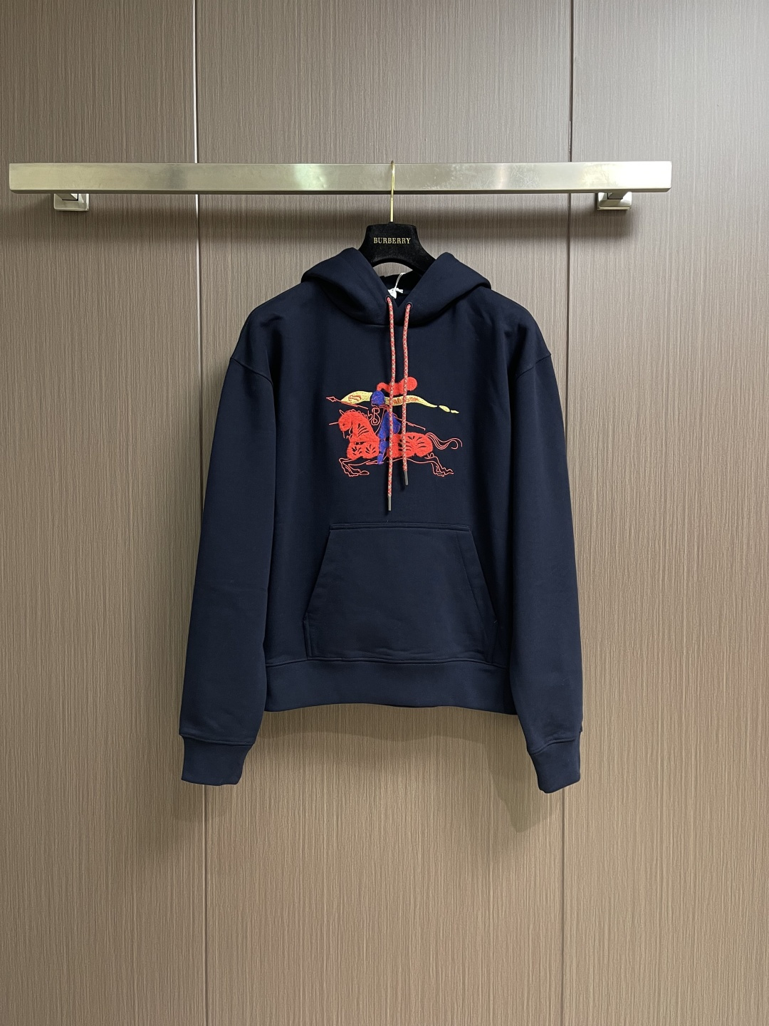 NO:683274,Tops and pants BURBERRY  The equestrian knight logo cotton hooded sweatshirt and sweatpants suit uses a 16-count double yarn top layer + a 10-count yarn bottom layer of turned-over velvet structure. Its weight makes it a heavyweight work among fabrics. By turning the high-density terry layer inside out and precision brushing, the surface of the fabric  It forms a relatively thick three-dimensional suede surface, which feels like touching young camel hair, while the interior remains relatively smooth to improve the smoothness of putting on and taking off. The rough texture and strong resilience of the double yarn rib perfectly match the heavy texture of the body. The equestrian knight logo is an innovative fusion.  The two processes of combined pile embroidery and metal silk embroidery first use untwisted fluffy mohair yarn to create the fluffy and soft three-dimensional texture of the logo body through seed embroidery and random stitch embroidery; then use coated metal silk embroidery thread to outline the outline and armor details, and superimpose a cold luster on the pile bottom. This tactile collision of warm fluff and cold metal gives the classic pattern a new sensory experience. Sizes S-XL, burberry, hoodie, sweatshirts, hats,19860909上衣 裤子 BURBERRY 马术骑士徽标棉质连帽卫衣卫裤套装,采用16支双纱面层＋10支纱底层的翻面绒结构,克重使其成为面料中的重量级作品.通过将高密毛圈层外翻并精密刷绒,织物表面形成相对厚度的立体绒面,触感如触摸幼驼绒毛,同时内部保持相对平滑以提升穿脱顺滑度.双纱罗纹其粗犷纹理与强大回弹力完美匹配衣身的厚重质感.马术骑士徽标创新融合绒毛绣与金属丝绣两种工艺先用未加捻的蓬松马海毛纱线,通过打籽绣与乱针绣塑造徽标主体蓬松柔软的立体肌理；再以镀膜金属丝绣线勾勒轮廓与盔甲细节,在绒底上叠加冰冷光泽.这种温感绒毛与冷感金属的触觉碰撞,让经典图案焕发全新感官体验.尺码S-XL,,burberry,hoodie,sweatshirts,hats,,Men's clothing