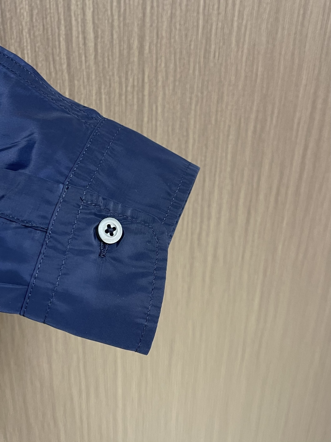 Prada 再生尼龙衬衫，Re-Nylon赋予这款经典剪裁衬衫技术风格，混搭设计融合裁缝优雅与功能性。圆