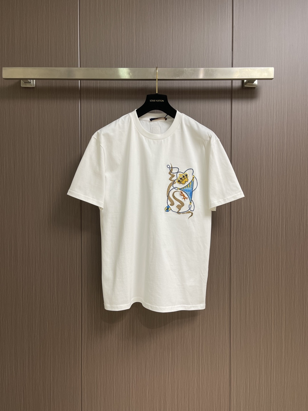 NO:691562,LV  The crown print short-sleeved T-shirt is made of imported heavyweight double-ply combed cotton fabric. It has a thick and full texture, is soft and skin-friendly and has excellent wrinkle resistance. It has excellent moisture absorption and breathability. It is not easy to deform and pill after long-term wear, ensuring the comfort and durability of the item. The neckline adopts a classic round neck cut, with thickened ribbing technology, which is resistant to pulling and pulling.  It is loose and fits the neck line more neatly and elegantly; the left chest is decorated with a crown print pattern, multi-color embroidery threads are interwoven with three-dimensional embroidery technology, the pattern is lifelike and rich in layers, becoming the visual focus of the body and breaking the dull feeling of the body; the body uses seamless side seam splicing technology to reduce friction and discomfort when wearing. Size S-XL  Size S, shoulder width 56.5, bust 106, length 70, size M, shoulder width 58, bust 110, length 72, size L, shoulder width 60.5, bust 114, length 74, size19860909LV 皇冠印花短袖T恤,采用进口重磅双股精梳棉面料,质感厚实饱满,触感柔软亲肤且抗皱性优异,吸湿性与透气性俱佳,久穿不易变形起球,保障了单品的舒适穿着与耐用性；领口采用经典圆领剪裁,搭配加厚罗纹包边工艺,耐拉扯不易松垮,贴合颈部线条更显利落大方；左胸位置饰有皇冠印花图案,多色绣线交织搭配立体刺绣工艺,图案栩栩如生、层次丰富,成为衣身视觉焦点,打破衣身的沉闷感；衣身采用无缝侧缝拼接工艺,减少穿着时的摩擦不适感.尺码S-XL  S码肩宽56.5 胸围106 衣长70 M码 肩宽58 胸围110 衣长72 L码肩宽60.5 胸围114 衣长74 XL码 肩宽62 胸围118 衣长76,,louis vuitton,T-shirt,tees，t-shirt,,Men's clothing