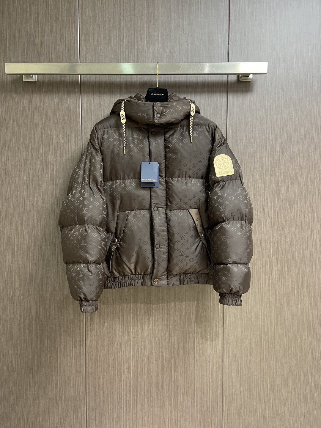 NO:690727,LV  SKI ski series printed down jacket, this LV dark pattern down jacket is made of customized jacquard fabric technology. The body is made of high-gloss nylon material, and the whole body is embossed with Monogram dark pattern. The seamless fusion of pattern and fabric is achieved through fine hot pressing process. It has both texture and recognition. It adopts zoned down filling quilting technology and divides down filling areas according to ergonomics to ensure warmth while avoiding bloat;  The hooded design is equipped with an adjustable drawstring (with leather trim), and the double-button closure at the collar enhances windproofness. The pockets are three-dimensional patch pockets + hidden snap-button structure. The cuffs and hem are edged with elastic ribs. The metal snaps in the details echo the brand logo. The overall body is adapted to a variety of body shapes through 3D tailoring, taking into account functionality and luxury. The overall routing is straight and delicate, the fabric is comfortable and soft, and the colors are consistent without color difference.  It can be matched with the same style to create a fashionable look, and can be used in various occasions. Customized accessories, complete with three standards, same style for men and women!  Size 48-50-52-54 48 size bust 130 shoulder width 56 length 68 50 size bust 134 shoulder width 58 length 70 52 size bust 138 shoulder width 60 length 72 54 size bust 142 shoulder width 62 length 74,,louis vuitton,down jacket,hats,19860909LV SKI滑雪系列印花羽绒服,这件LV暗纹羽绒服采用定制提花面料工艺衣身选用高光泽感尼龙材质,通体压印品Monogram暗纹,通过精细热压工艺实现图案与面料的无缝融合,兼具质感与辨识度采用分区充绒绗缝技术,按人体工学划分充绒区域,保证保暖性的同时避免臃肿；连帽设计搭配可调节抽绳（配皮质饰片）,领口双纽扣闭合增强防风性口袋为立体贴袋＋隐藏式按扣结构,袖口与下摆采用弹性罗纹收边,细节处的金属按扣与品牌标识呼应,整体通过3D立体剪裁适配多种身形,兼顾功能性与奢华感.整体走线平直细腻,面料舒适柔软,颜色一致无色差 能与同款搭配营造时尚造型,驾驭各种场合,定制辅料,三标齐全,男女同款！尺码48-50-52-54 48码 胸围130 肩宽56衣长68 50码 胸围134 肩宽58衣长70 52码 胸围138 肩宽60衣长72 54码 胸围142 肩宽62衣长74,,louis vuitton,down jacket,hats,,Men's clothing