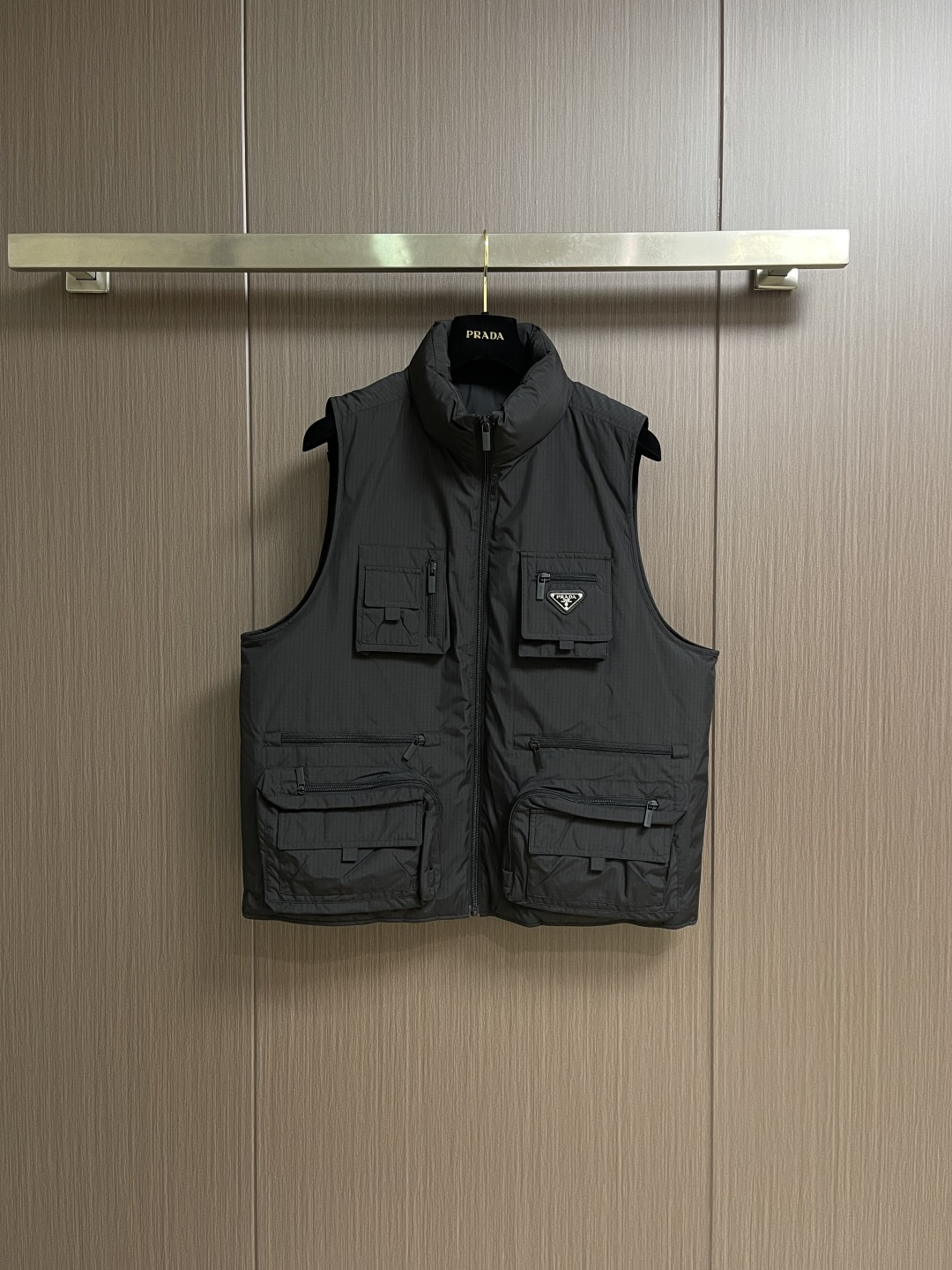 PRADA 三角标工装风秀款羽绒马甲外套，标志性的三角形徽标重释为经典图案，化身此款Re-Nylon再生