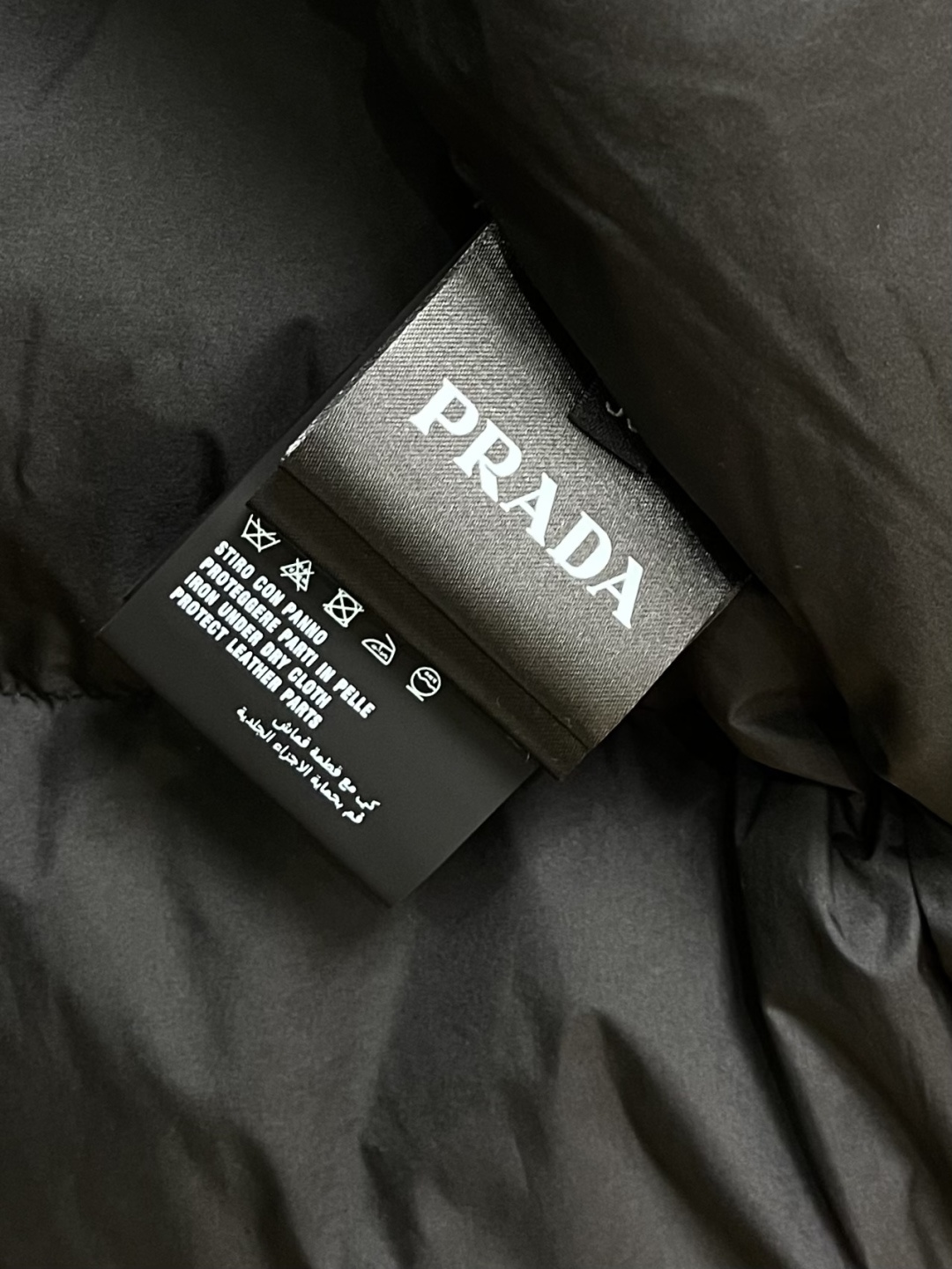 PRADA 三角标工装风秀款羽绒马甲外套，标志性的三角形徽标重释为经典图案，化身此款Re-Nylon再生