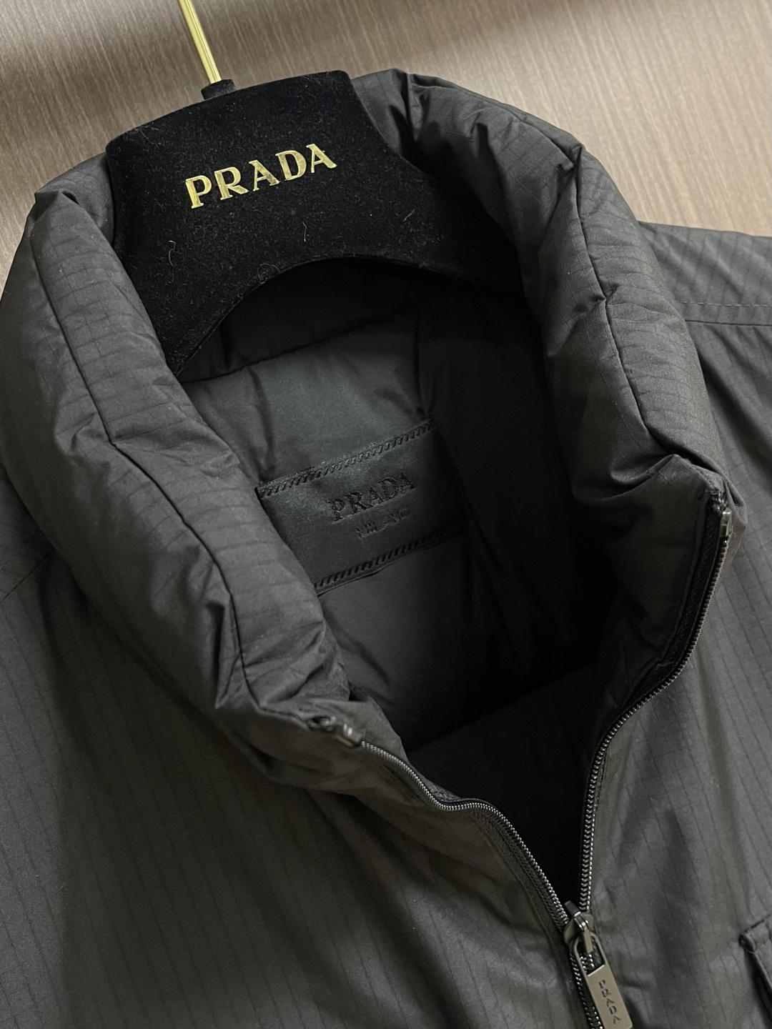PRADA 三角标工装风秀款羽绒马甲外套，标志性的三角形徽标重释为经典图案，化身此款Re-Nylon再生