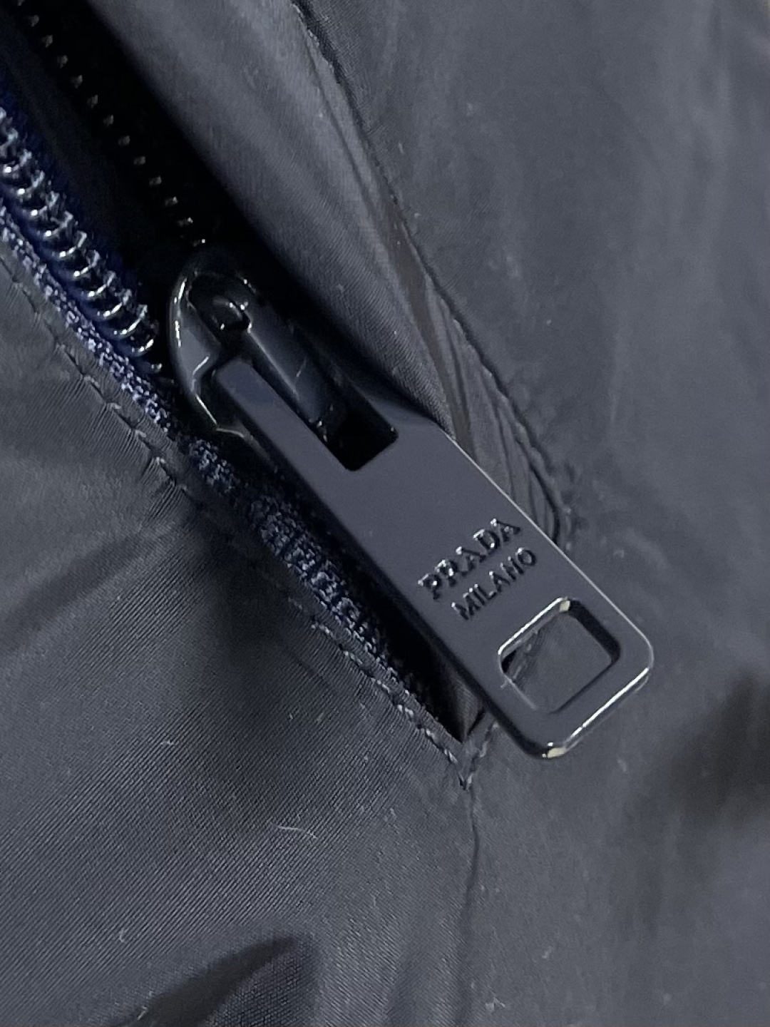 Prada Re-Nylon限定款连帽羽绒服夹克外套，这款再生尼龙羽绒饰有三角形金属徽标等精美细节，并融