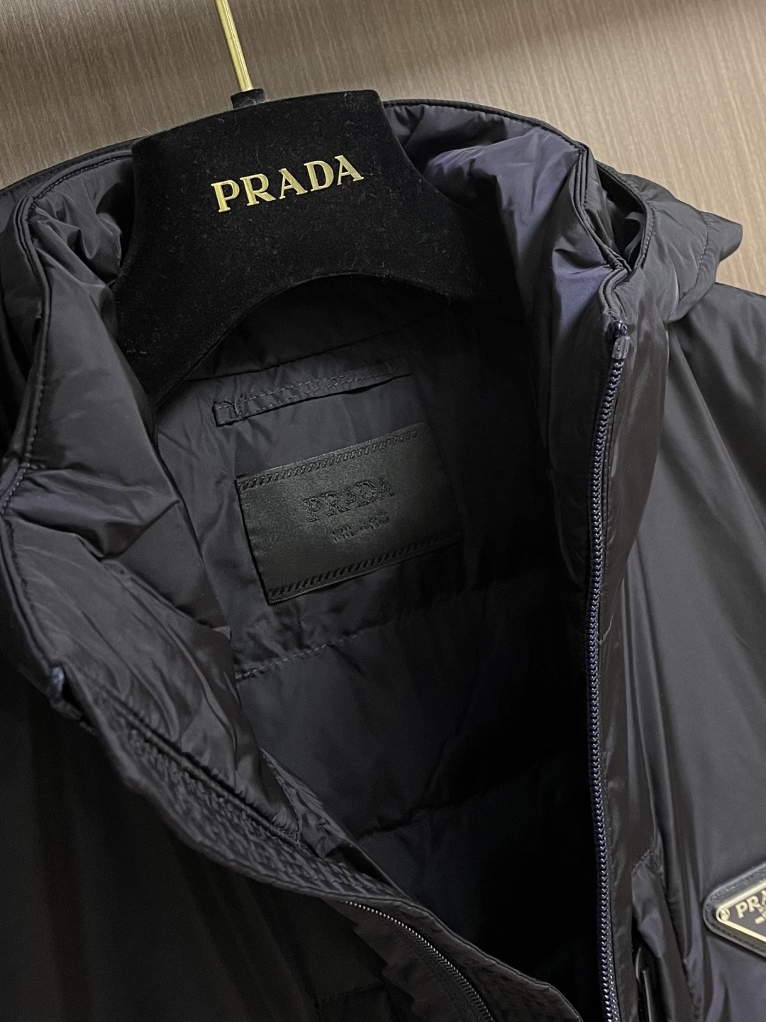 Prada Re-Nylon限定款连帽羽绒服夹克外套，这款再生尼龙羽绒饰有三角形金属徽标等精美细节，并融