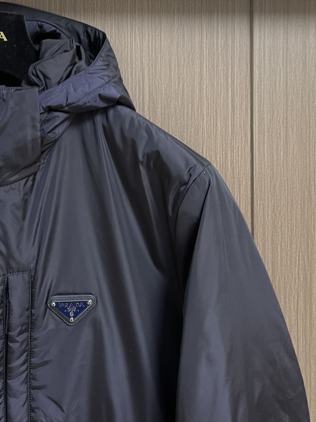 Prada Re-Nylon限定款连帽羽绒服夹克外套，这款再生尼龙羽绒饰有三角形金属徽标等精美细节，并融