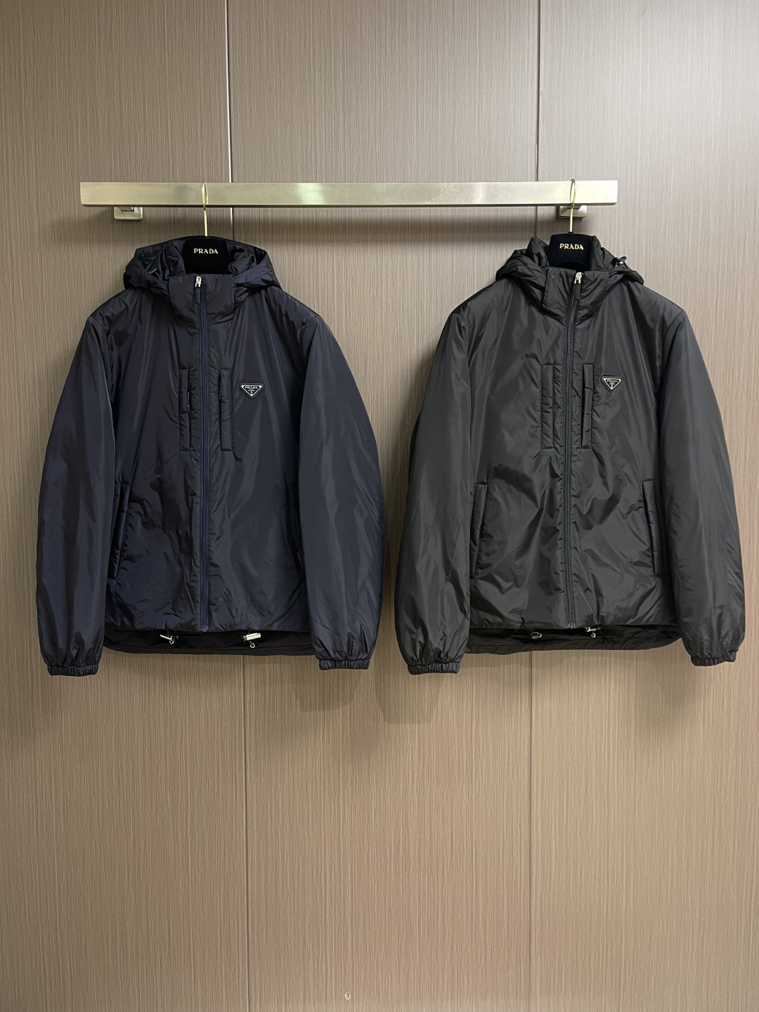 Prada Re-Nylon限定款连帽羽绒服夹克外套，这款再生尼龙羽绒饰有三角形金属徽标等精美细节，并融