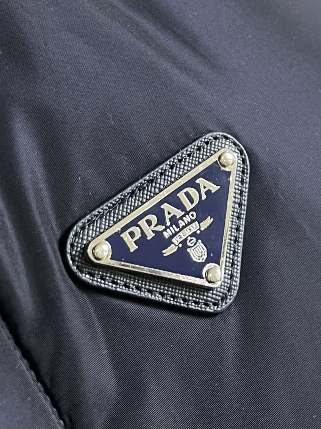 Prada Re-Nylon限定款连帽羽绒服夹克外套，这款再生尼龙羽绒饰有三角形金属徽标等精美细节，并融