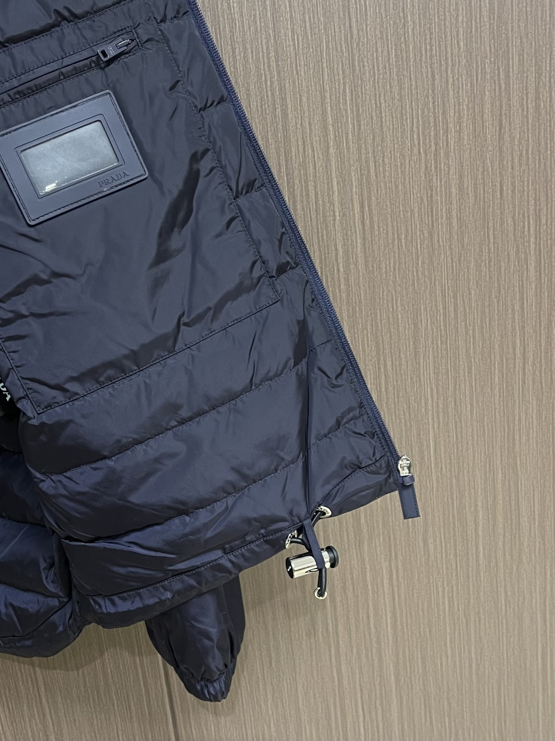 Prada Re-Nylon限定款连帽羽绒服夹克外套，这款再生尼龙羽绒饰有三角形金属徽标等精美细节，并融