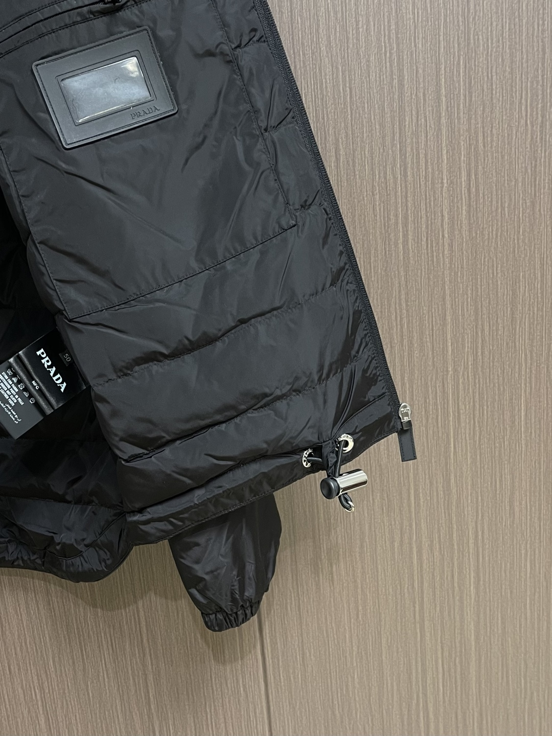 Prada Re-Nylon限定款连帽羽绒服夹克外套，这款再生尼龙羽绒饰有三角形金属徽标等精美细节，并融