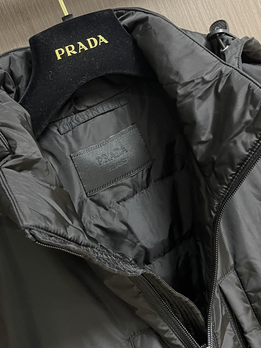 Prada Re-Nylon限定款连帽羽绒服夹克外套，这款再生尼龙羽绒饰有三角形金属徽标等精美细节，并融