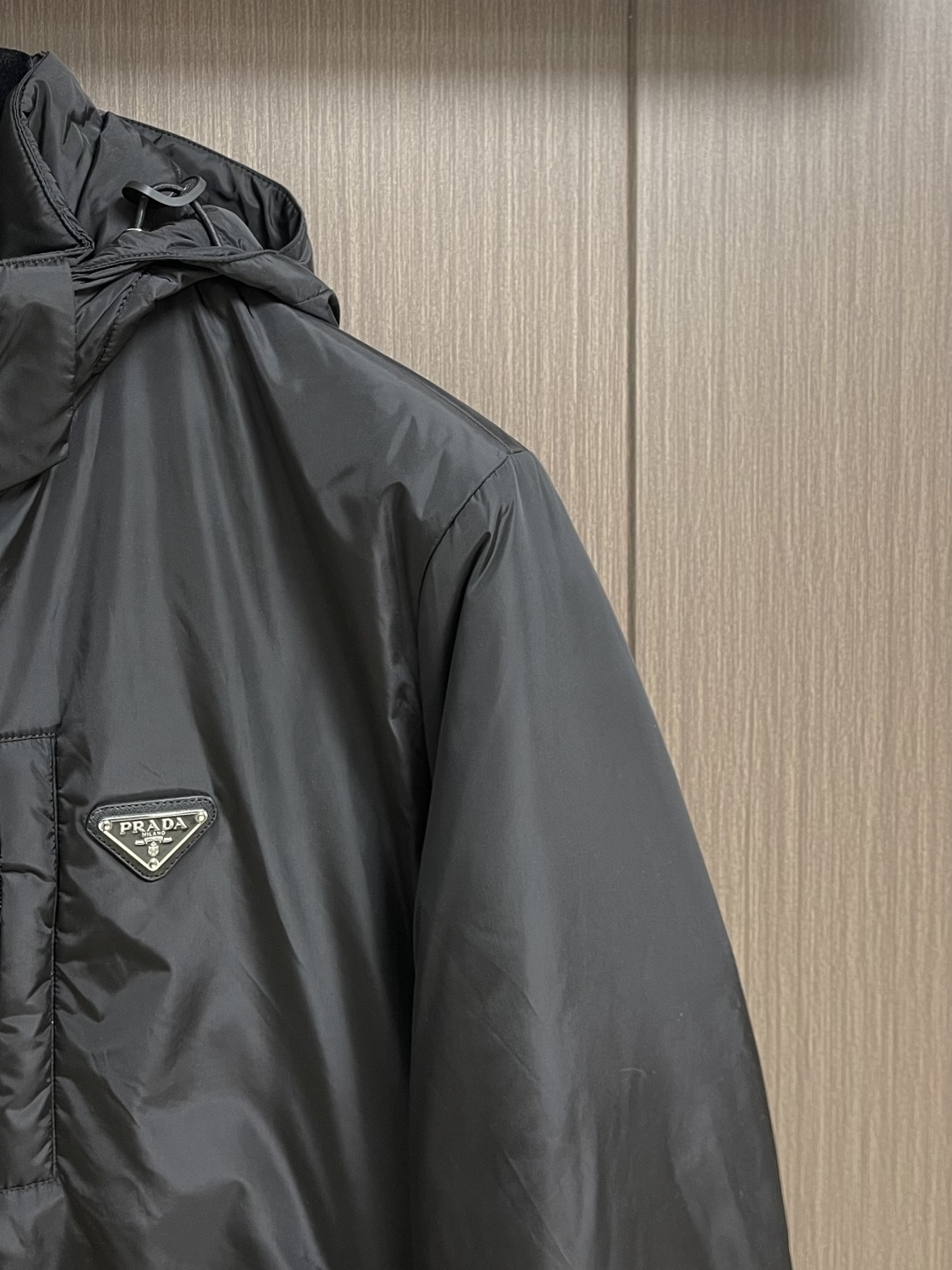 Prada Re-Nylon限定款连帽羽绒服夹克外套，这款再生尼龙羽绒饰有三角形金属徽标等精美细节，并融