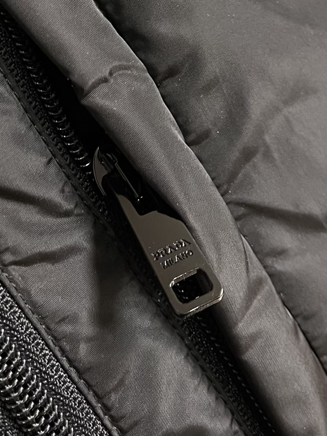 Prada Re-Nylon限定款连帽羽绒服夹克外套，这款再生尼龙羽绒饰有三角形金属徽标等精美细节，并融