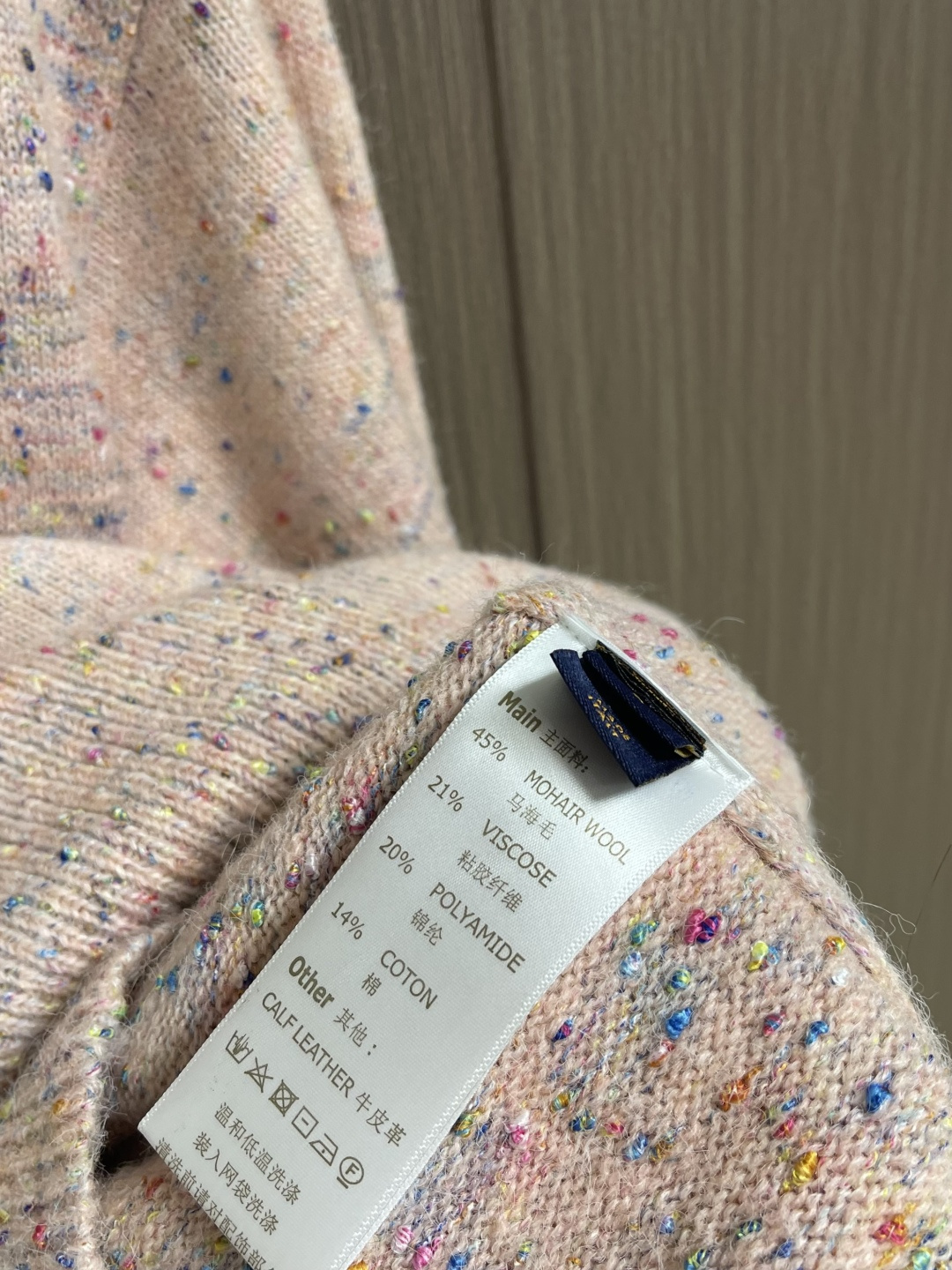 LV 字母徽章樱花粉珍珠扣羊毛针织开衫毛衣，这款路易威登SS26春夏系列粗花呢翻领开衫，甄选羊驼毛与美利