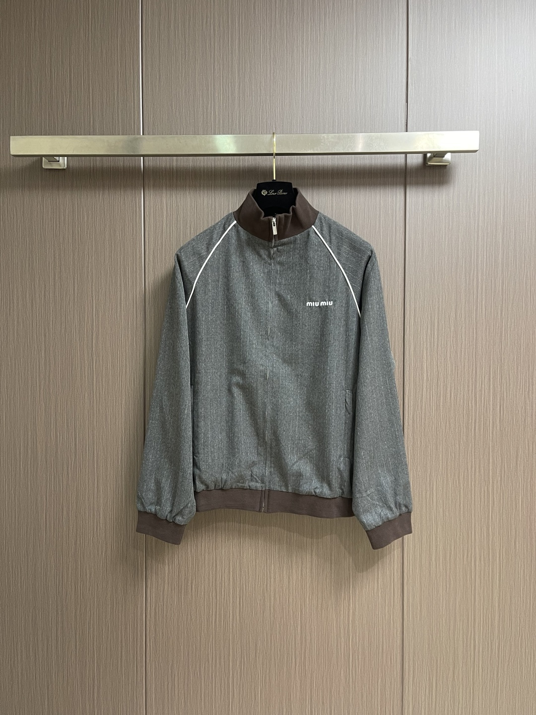 MIUMIU 立领细条纹拉链夹克外套，这款灰色细条纹夹克采用精梳羊毛混纺面料，经高温定型处理，具有良好的