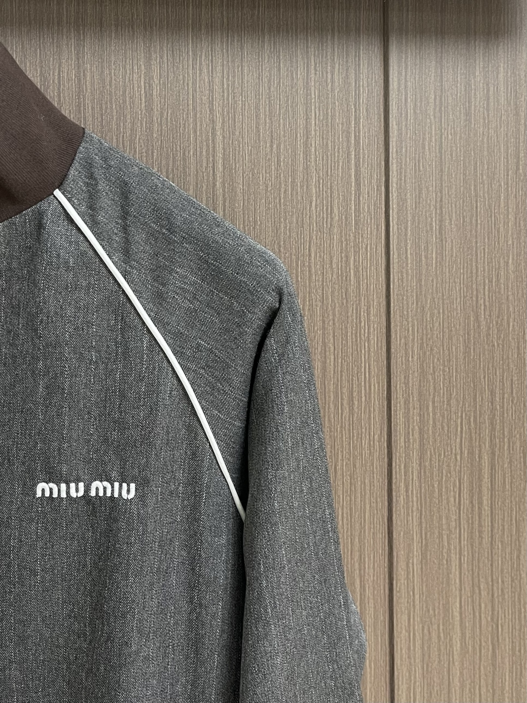MIUMIU 立领细条纹拉链夹克外套，这款灰色细条纹夹克采用精梳羊毛混纺面料，经高温定型处理，具有良好的