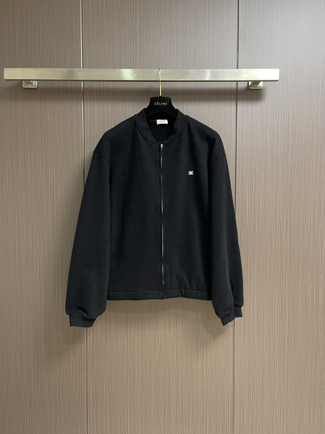 NO:730607,Celine's embroidered baseball jacket, which supports after-sales service after the year, is made of single-sided fish-scale fabric woven with cotton as the base. The front is a smooth knitted surface, and the skin-contacting surface is formed into three-dimensional terry by the floating thread knitting technology of the knitting machine to increase the fluffy feel.  At the same time, it feels delicate to the touch. The terry structure absorbs a lot of water and evaporates quickly, so it is not easy to loosen and deform after repeated washing. The hat body and side pockets are made of nylon fabric, which is wear-resistant and has good windproof performance as the hat body. The baseball collar adopts a double-layer cotton rib structure. After high-temperature pre-shrinking treatment, the highest point of the collar is fixed at 6cm, which not only fits the neck curve but is not easy to change.  Shape. The ribbed trim of the cuffs is made of 80-count high-elastic spandex blended thread. It is tightly woven with 16 stitches to form a high-elastic edge, which not only retains the sense of vitality, but also avoids the tight constraints of traditional ribs. By actively intervening in the shrinkage potential of cotton fibers, the fabric is achieved from being variable to stable, improving dimensional stability and making it less susceptible to wear and tear.  Deformation and wrinkles. The Tajima high-speed embroidery machine is equipped with a 12-pin position independent control system and a 0.01mm stepper motor to achieve high-speed operation of 1,200 stitches per second. The machine is equipped with an intelligent thread breakage detection function that can automatically stop within 0.3 seconds of thread breakage to avoid stitch misalignment; the tension closed-loop control system adjusts the surface in real time  Thread and bottom thread tension (range 5-30cN) ensures that the white embroidery thread is three-dimensional and full on the black terry cloth without being tight and wrinkled. The S-shaped curve of the pattern adopts the minimum stitch distance, and the stitch angle changes in real time with the curvature of the curve to form a continuous and smooth line. 360° circular stitches are stacked to create a three-dimensional raised feeling. Size S-XL  Size S, bust 114, shoulder width 57, length 65, size M, bust 118, width 58, length 66, size L, bust 122, width 59, length 67,19860909支持年后售后 Celine 饰刺绣棒球夹克外套,选用棉为基底编织而成的单面鱼鳞布面料,正面为平滑的针织面,触肤面通过针织机的浮线编织技术形成立体的毛圈,增加蓬松感, 同时触感细腻.毛圈结构吸水量大且蒸发快,多次洗涤不易松散变形.帽身和侧插袋选用尼龙面料,耐磨且作为帽身具有良好的防风性能.棒球领采用双层棉织罗纹结构,经高温预缩处理后,领最高点固定在6cm,既贴合颈部曲线又不易变形.袖口的罗纹饰边则选用80支高弹氨纶混纺线,通过16针英寸的紧密编织,形成高弹力收边,既保留活力感,又避免传统罗纹的紧绷束缚.通过主动干预棉纤维收缩潜能,实现了面料从易变到稳定的跨越,提升了尺寸稳定性,同时不易变形,褶皱.采用田岛高速绣花机,搭载12针位独立控制系统与0.01mm级步进电机,实现每秒钟1200针的高速运转.机器配备的智能断线检测功能,能在断线0.3秒内自动停机,避免针脚错位；张力闭环控制系统则实时调节面线与底线张力（范围5-30cN),确保白色绣线在黑色毛圈布上既立体饱满又不紧绷起皱.图案的S形曲线采用最小针距,针迹角度随曲线弧度实时变化,形成连续流畅的线条.以360°环形针迹堆叠,打造立体凸起感.尺码S-XL S码胸围114肩宽57 衣长65 M码 胸围118肩宽58 衣长66 L码胸围122肩宽59 衣长67 XL码 胸围126肩宽60 衣长68,,celine,jackets & coats,jackets & coats,hats,,Men's clothing