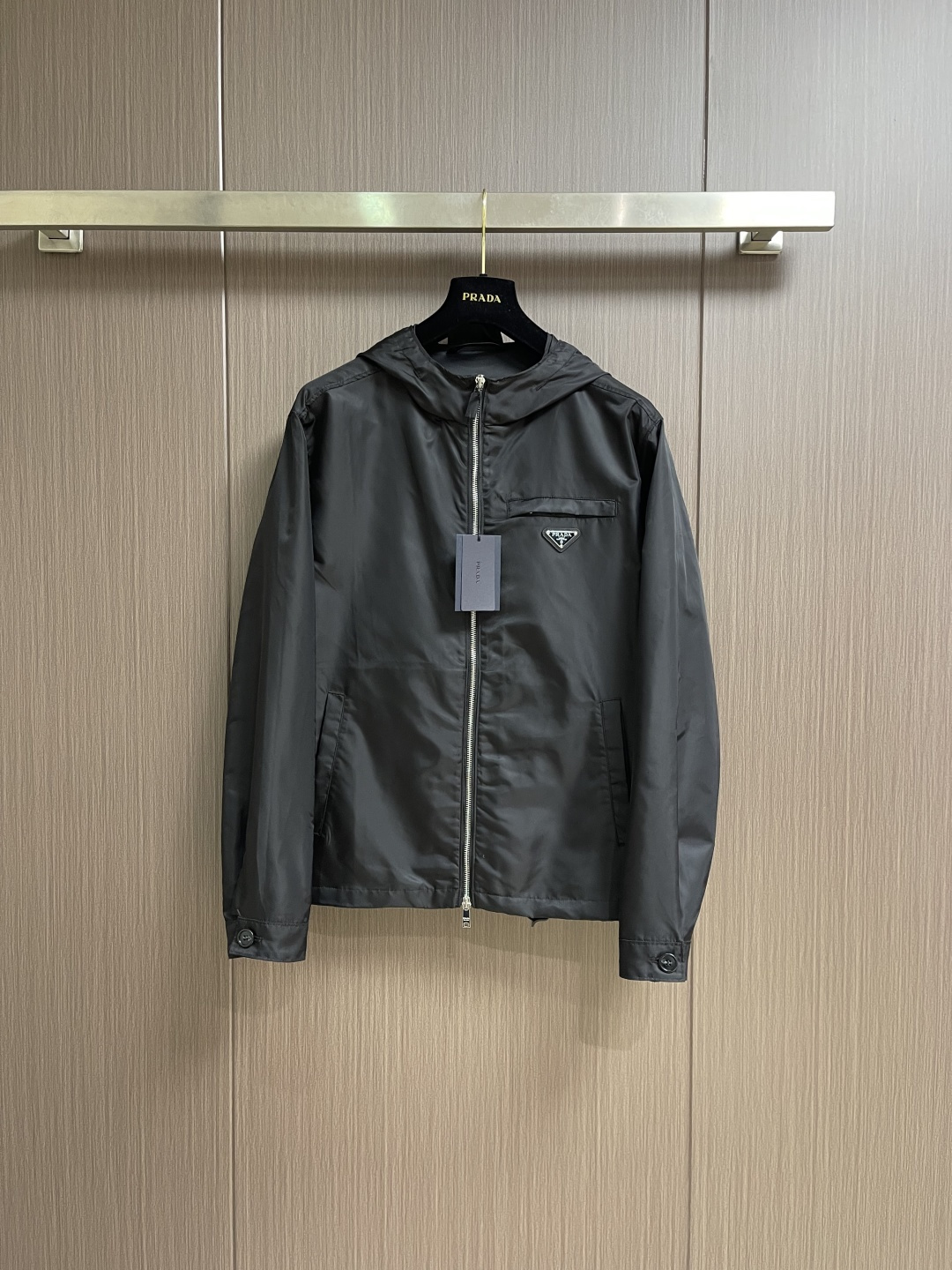 NO:735434,Support after-sales service after the year  The Prada regenerated nylon hooded jacket is made of the brand's iconic regenerated nylon fabric, which has the same performance as traditional nylon and has high strength, tear resistance, abrasion resistance and other properties. Its texture is light and waterproof, suitable for many scenarios.  Requirements. It is anti-wrinkle and quick-drying, making it easy to care for and maintain on a daily basis. The customized triangle logo is fixed to the body of the garment through four 0.8mm metal claw nails. The backs of the claw nails are polished by hand to be rounded to avoid scratches. The elastic drawstring at the hem is made of 7-core high-elastic nylon rope, which is straight.  The diameter is 3mm, and with the rubber buckle, the length can be adjusted by ±5cm. The drawstring hole is double protected by 'metal eyelet + anti-wear ring'. The inner diameter of the eyelet is 5mm, the edge is smooth and burr-free, and it can be pulled out 500 times without deformation. The cuffs adopt a button adjustment system.  System, two black resin buttons can adjust the cuff circumference ±2cm, adapting to different wrist sizes, ensuring that it fits the wrist without drafts. The cut of the straight sleeves strictly follows ergonomics, and the armhole curvature is set to 115°, so there is no sense of restraint when moving. Sizes S-XL  Size S, bust 118, shoulder width 49, length 69, size M, bust 122, shoulder width 50, length 70, size L, bust 126, shoulder width 51, size L, bust 126, shoulder width 51, size XL, bust 130, shoulder width 52, length 72,19860909支持年后售后 Prada再生尼龙连帽夹克外套,面料选用品牌标志性的再生尼龙面料,与传统尼龙性能相当,具备高强度,抗撕裂,耐磨损等特性.其质地轻盈,同时又具备防水功能适合多场景需求.抗皱,快干的特点也易于日常打理维护.定制三角徽标通过4个0.8mm金属爪钉固定于衣身,爪钉背面经手工打磨至圆润,避免刮蹭.下摆弹力抽绳选用7芯高弹尼龙绳,直径3mm,配合橡胶扣,可实现±5cm长度调节.抽绳孔采用「金属鸡眼＋防磨环」双重保护,鸡眼内径5mm,边缘光滑无毛刺,反复抽拉500次无变形.袖口采用纽扣调节系统,两颗黑色树脂纽扣可调节袖口围度±2cm,适应不同手腕尺寸,确保贴合手腕不灌风.直筒袖剪裁严格遵循人体工学,袖窿弧度设定为115°,活动时无束缚感.尺码S-XL S码胸围118 肩宽49 衣长69 M码 胸围122肩宽50 衣长70 L码胸围126肩宽51 衣长71 XL码 胸围130肩宽52 衣长72,,prada,jackets & coats,jackets & coats,hats,,Men's clothing