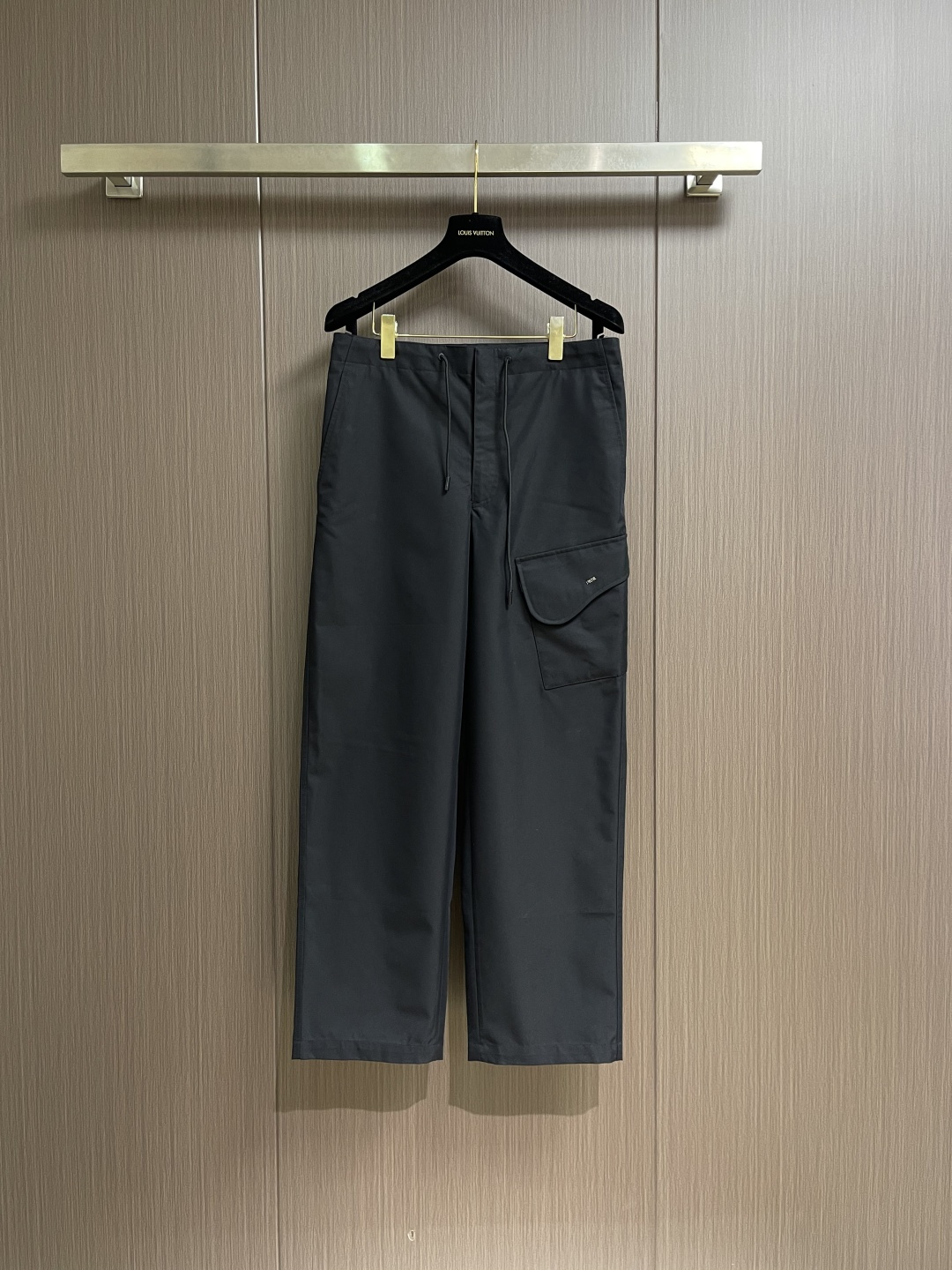 NO:730649,Support after-sales service Dior  Black cotton twill overalls are made of a blend of double-ply combed cotton and polyester fiber, interwoven with the '31 right twill' weaving method. The twill angle is 45° and contains 8-10 weaving points per centimeter, forming a fine and tight texture. The fabric weighs 280gm2, and the thickness is moderate but not thick.  The bloated fabric has been 'enzyme washed' on the surface to remove loose hair and give it a slightly aged texture. The hollow structure of the cotton fiber accelerates air circulation, and combined with the breathable pores of the twill weave, it will not make you sweaty when worn in summer. The abrasion resistance of the polyester fiber makes the fabric washable and durable, and it is not prone to pilling and snagging due to daily friction.  There are three-dimensional saddle-shaped flap pockets on the outside of the trouser legs, and the pockets have a smooth arc design. The edge of the flap adopts 'double-needle topstitching' technology with even stitch spacing (10 stitches every 3cm), which not only strengthens the edge but also forms decorative lines. The metal Dior logo is inlaid in the center of the top of the flap. It is made of zinc alloy and processed by electroplating process. It has a uniform color and is not easy to oxidize. The waist has a built-in double-layer thickened waistband and a built-in high-density nylon drawstring. The rope head is decorated with a metal bell for smooth pulling.  And it is not easy to loosen. The tightness can be adjusted freely according to the waist circumference, taking into account comfort and fit, and avoiding the tight feeling of traditional overalls. The front placket adopts an invisible zipper, which is double fixed with a metal hook. The zipper teeth are fine and smooth, and it is silent and smooth when pulled.  Smooth; opening and closing is convenient and firm, ensuring that it is not easy to open accidentally during wearing. There are classic diagonal slit pockets on both sides of the trousers, and the edge of the pocket adopts 'edging + double needle' process to prevent off-line. Sizes 46-52,, dior,19860909支持年后售后 Dior 黑色棉质斜纹工装裤,采用双股精梳棉与聚酯纤维混纺而成,经'31右斜纹'织法交织而成,斜纹角度45°,每厘米含8-10个织点,形成细密紧实的纹路.面料克重达280gm2,厚度适中却不臃肿,表面经'酵素水洗'处理,去除浮毛并赋予轻微做旧肌理.棉纤维的中空结构加速空气流通,配合斜纹织法的透气孔道,夏季穿着不闷汗；聚酯纤维的耐磨性使面料耐洗耐穿,日常摩擦不易起球勾丝. 裤腿外侧缀立体马鞍形翻盖口袋,袋口呈流畅的弧形设计,翻盖边缘采用'双针明线'工艺,针距均匀（每3cm10针）,既加固边缘又形成装饰性线条.翻盖顶部中央镶嵌金属Dior标志,采用锌合金材质,经电镀工艺处理,色泽均匀,不易氧化.腰部内置双层加厚腰头,内藏高密度尼龙抽绳,绳头缀有金属吊钟,拉动顺畅且不易松脱.可根据腰围自由调节松紧,兼顾舒适与贴合,避免传统工装裤的紧绷感.前门襟采用隐形拉链,配合金属钩扣双重固定,拉链齿细密光滑,拉动时静音顺畅；开合便捷且牢固,确保穿着过程中不易意外敞开.裤身两侧为经典斜插式开缝口袋,袋口边缘采用'包边＋双针'工艺,防止脱线.尺码46-52,,dior,,Men's clothing