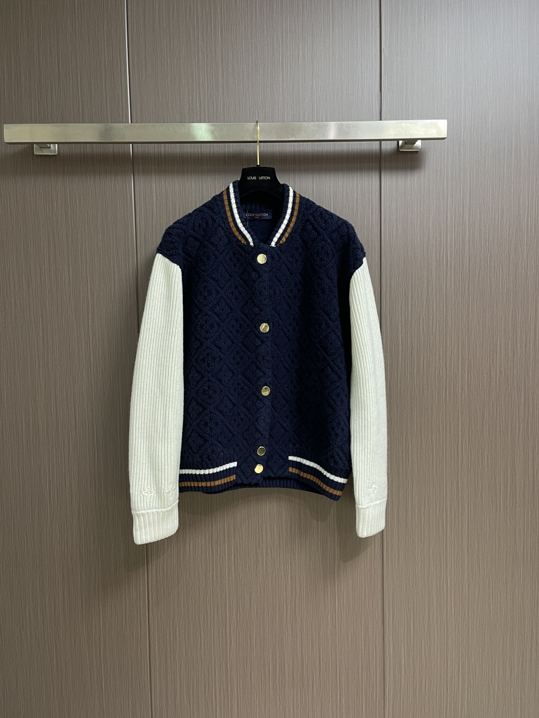 NO:730595,Support after-sales LV after the year  SKI ski series color-blocked striped baseball long-sleeved jacket. This Louis Vuitton color-blocked knitted cardigan uses three-dimensional cable knitting technology to create the main body. It uses high-count merino wool blended fabric and is woven with a double needle bed knitting machine to create concave and convex shapes.  The unique rhombus texture has a knitting density of 32 stitches per square centimeter, giving the texture both three-dimensionality and softness. The main body of the garment is made of navy blue custom-spun yarn, which has been washed and fixed for three times to effectively prevent fading. The sleeves are made of off-white vertical pits.  Striped rib knitting, the twist of a single yarn is controlled at 800 twist meters to ensure resilience and fit. The metal snaps are made of customized brass and treated with gold-plated glaze sealing process; the contrasting ribs on the collar and hem are intarsia woven to accurately match the brand.  The classic three-color webbing proportions, and the laser-engraved brand logo hidden on the cuffs. The overall process combines traditional knitting techniques with modern precision workmanship, and the details show the level of craftsmanship. The overall routing is straight and delicate, the fabric is comfortable and soft, and the colors are consistent without color difference.  It can be matched with the same style to create a fashionable look, and can be used in various occasions. Customized accessories, complete with three standards, same style for men and women!  Size S-XL S size Bust 110 Shoulder width 48 Dress length 63.5 Medium Bust 114 Shoulder width 50 Dress length 65.5 Large Size Bust 118 Shoulder width 52 Dress length 67.519860909支持年后售后 LV SKI滑雪系列拼色条纹棒球长袖外套,这款路易威登拼色针织开衫采用立体绞花编织工艺打造主体衣身,选用高支数美利奴羊毛混纺面料,通过双针床针织机织造出凹凸有致的菱格纹理,每平方厘米编织密度达32针,让纹理兼具立体感与柔软度；衣身主体为藏青色定纺纱线,经三次水洗固色处理,有效防止褪色.袖子部分采用米白色竖坑条罗纹针织,单股纱线捻度控制在800捻米,保证回弹性与贴合度.金属按扣为定制黄铜材质,经镀金封釉工艺处理；领口、下摆的撞色罗纹采用嵌花编织,精准对接品牌经典三色织带比例,袖口处还暗藏激光雕刻的品牌标识,整体工艺融合传统针织技法与现代精工,细节处尽显匠造水准.整体走线平直细腻,面料舒适柔软,颜色一致无色差 能与同款搭配营造时尚造型,驾驭各种场合,定制辅料,三标齐全,男女同款！尺码S-XL S码 胸围110 肩宽48 衣长63.5 M码 胸围114 肩宽50 衣长65.5 L码 胸围118 肩宽52 衣长67.5 XL码 胸围122 肩宽54 衣长69.5,,louis vuitton,louis vuitton,jackets & coats,gold plating,,Men's clothing