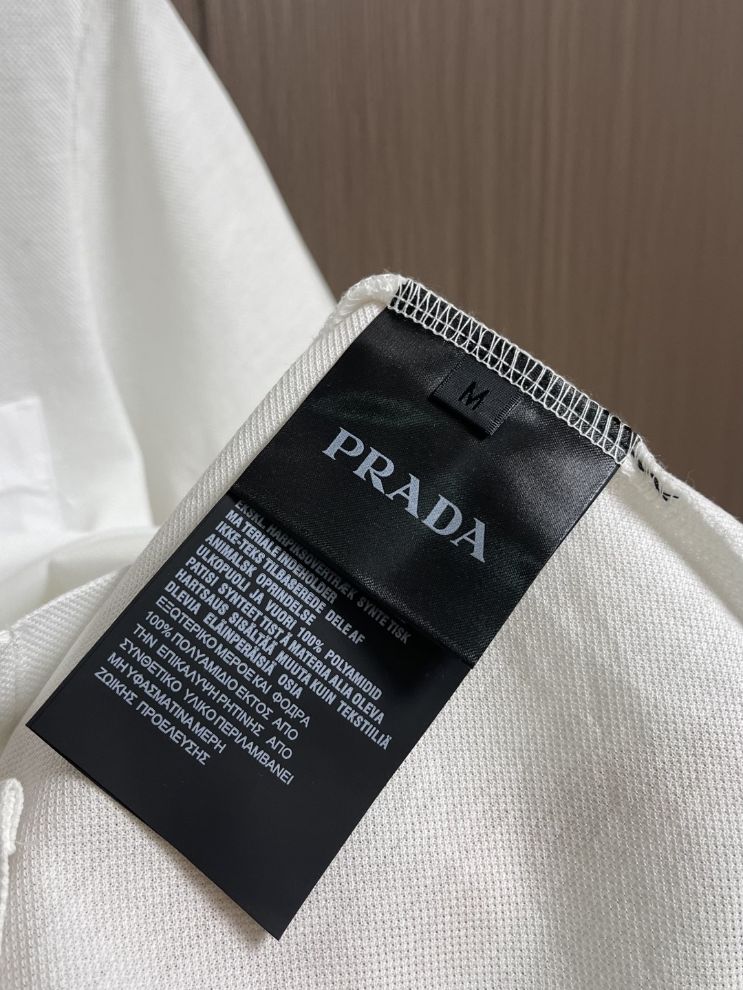 Prada 短袖翻领T恤Polo衫，采用原色有机棉，质地柔软，面料轻薄，纹理细腻清晰，版型宽松舒适，上身