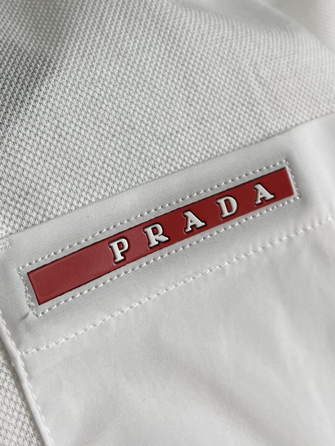 Prada 短袖翻领T恤Polo衫，采用原色有机棉，质地柔软，面料轻薄，纹理细腻清晰，版型宽松舒适，上身
