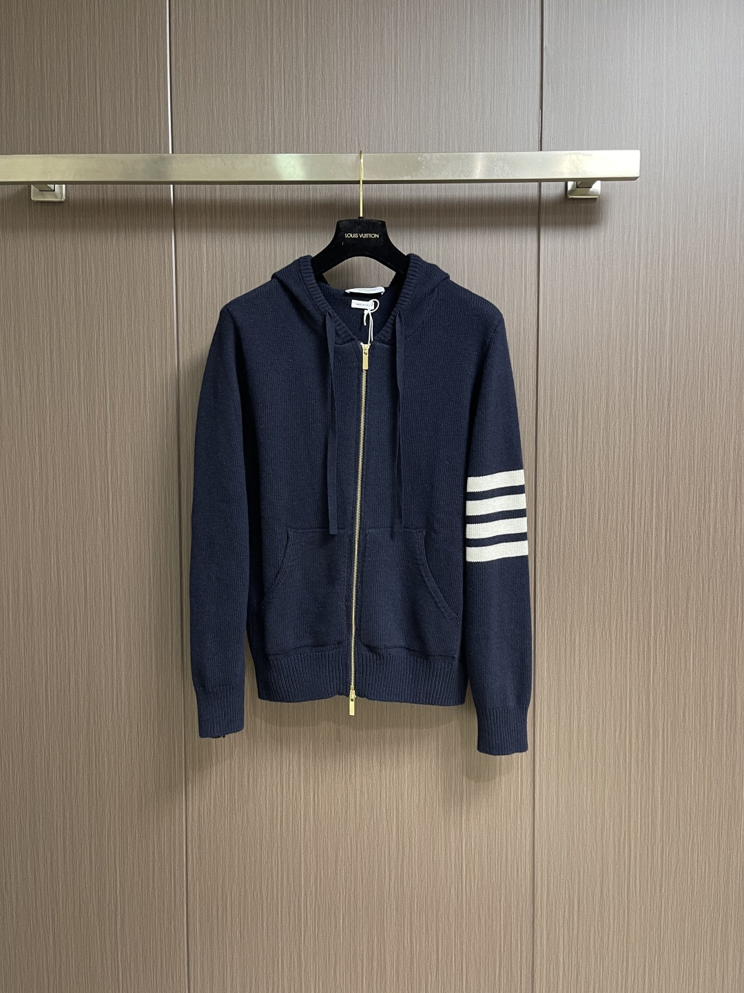 NO:744137,Thom Browne TB  The navy blue hooded knitted sweater has a relaxed academic feel. The horse graphics on the back are really hard work. This navy blue hooded sweater perfectly combines the sophistication of the academic style with the relaxed feeling of daily life. The classic navy background color has a calm temperament. The pony pattern on the back is the finishing touch. The delicate jacquard craftsmanship makes the whole thing more retro-childish.  Interesting. The four stripes on the left arm are iconic and recognizable. The red, white and blue woven label on the top of the hat is full of details, and it is low-key and has a sense of ritual exclusive to the brand. The soft and waxy knitted fabric is super comfortable to wear close to the body. The hooded design is both warm and casual. Whether worn alone or layered with a coat, you can easily create a relaxed and sophisticated academic style. Sizes 1-2-3-4  Size 1 Bust 102 Shoulder Width 42 Dress Length 66 Size 2 Bust 108 Shoulder Width 43 Dress Length 68 Size 3 Bust 114 Shoulder Width 44 Dress Length 70 Size 4 Bust 120 Shoulder Width 45 Dress Length 72,,sweaters,hats,19860909Thom Browne TB 风藏青连帽针织毛衣,学院派的松弛感,后背图形马是真的下了功夫的,这件藏青连帽针织衫,把学院风的精致和日常的松弛感完美揉在了一起,经典藏青底色自带沉静气质,背后的小马图案是点睛之笔,细腻的提花工艺让整体多了几分复古童趣.左臂四道杠是标志性的辨识度,帽顶的红白蓝织标细节拉满,低调中带着品牌专属的仪式感.软糯的针织面料贴身穿超舒服,连帽设计兼顾保暖与随性,不管是单穿还是叠穿大衣,都能轻松打造松弛又精致的学院风穿搭.尺码1-2-3-4 1码 胸围102 肩宽42衣长66 2码 胸围108 肩宽43衣长68 3码 胸围114 肩宽44衣长70 4码 胸围120 肩宽45衣长72,,sweaters,hats,,Men's clothing