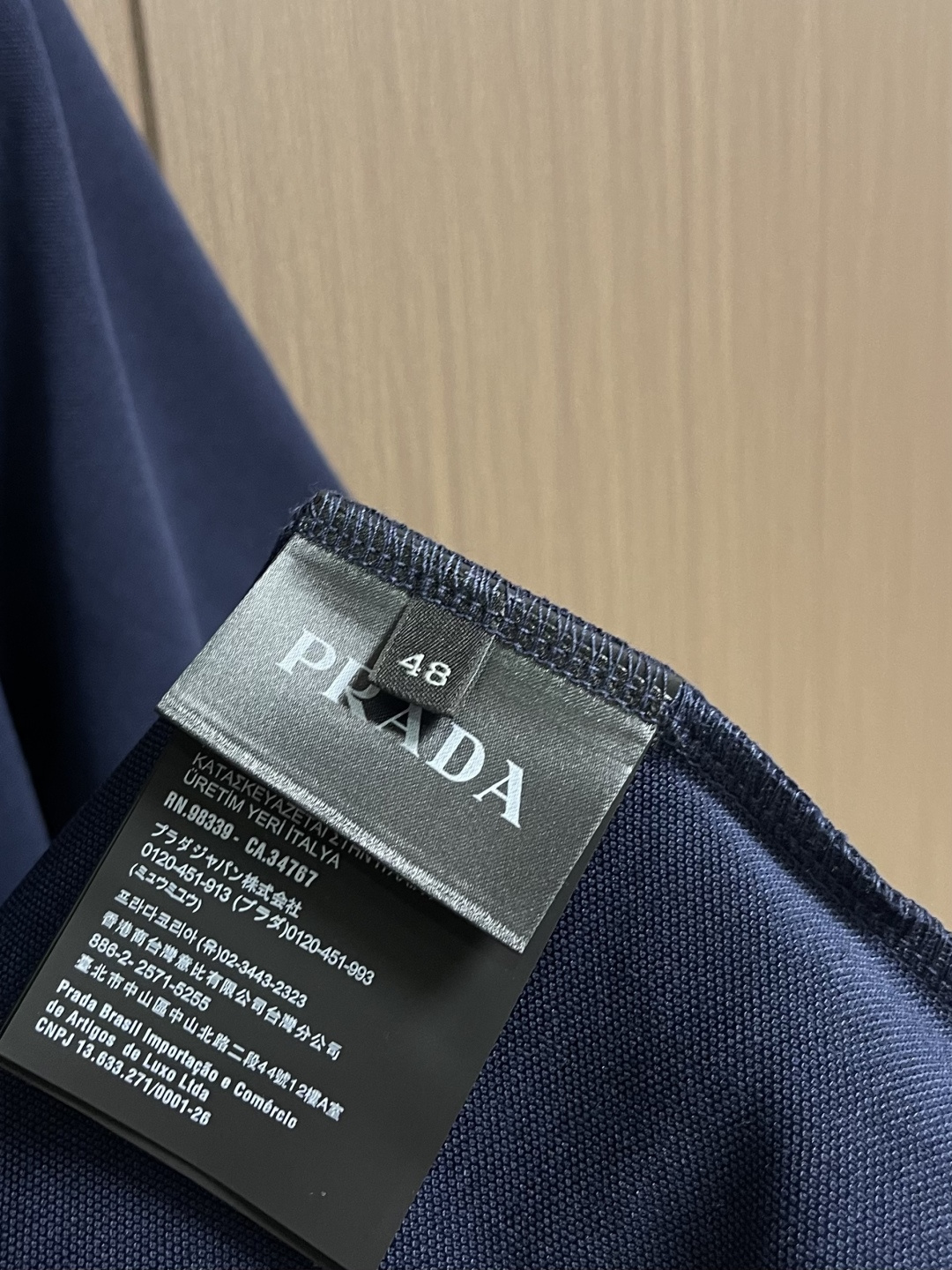 Prada 徽标刺绣抽绳Polo衫 定制粗颗纹路棉质帆布料 紧密细腻 高端精致 以糅合藏蓝与玄黑的低饱和