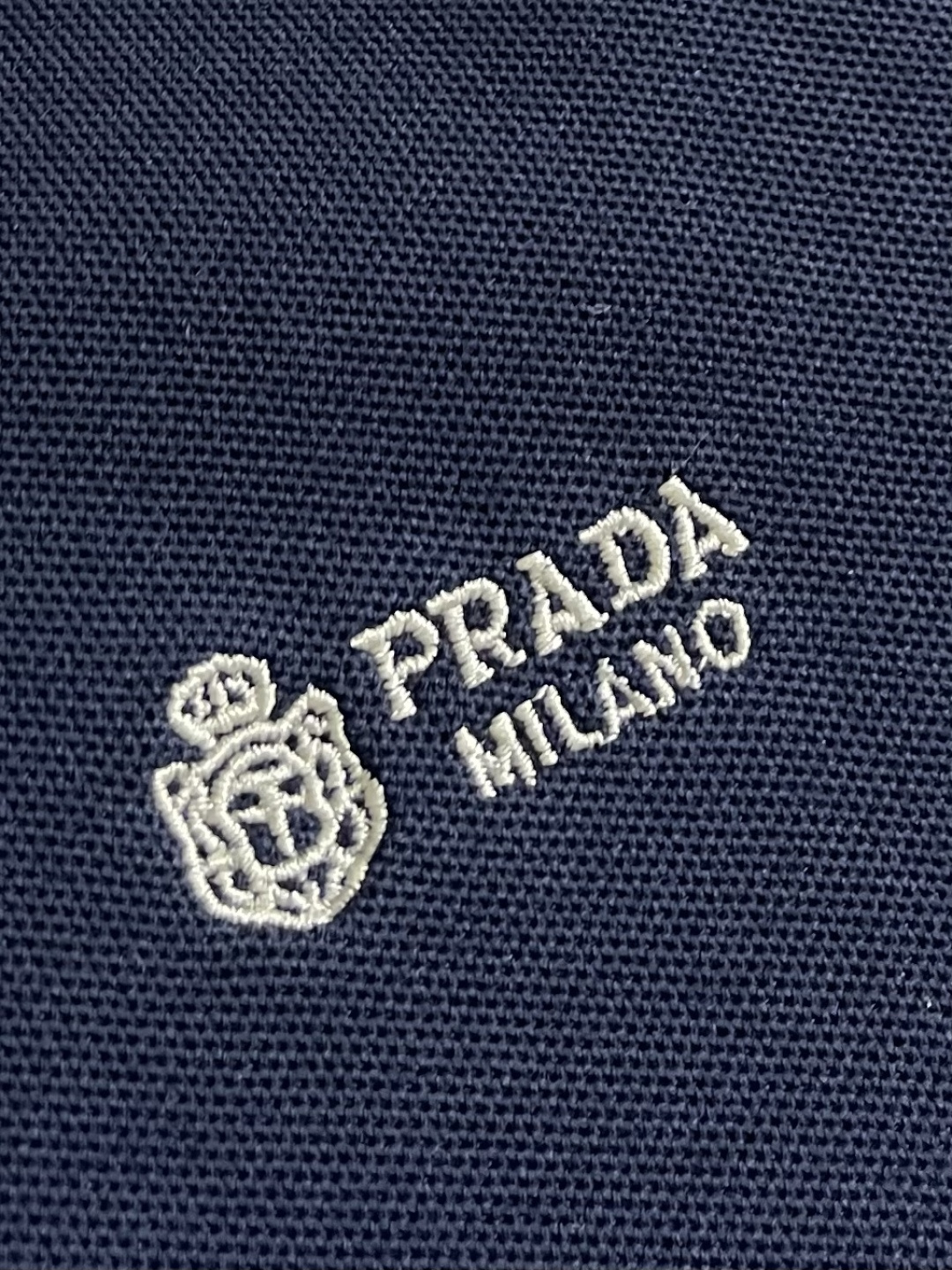 Prada 徽标刺绣抽绳Polo衫 定制粗颗纹路棉质帆布料 紧密细腻 高端精致 以糅合藏蓝与玄黑的低饱和