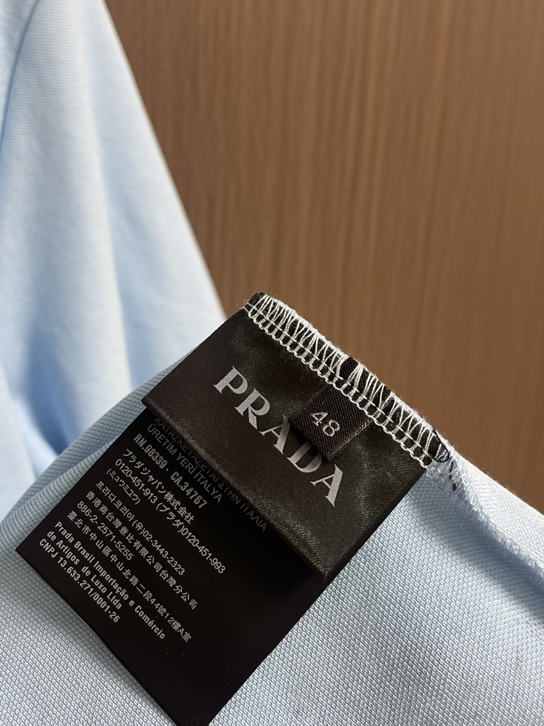 Prada 徽标刺绣抽绳Polo衫 定制粗颗纹路棉质帆布料 紧密细腻 高端精致 以糅合藏蓝与玄黑的低饱和