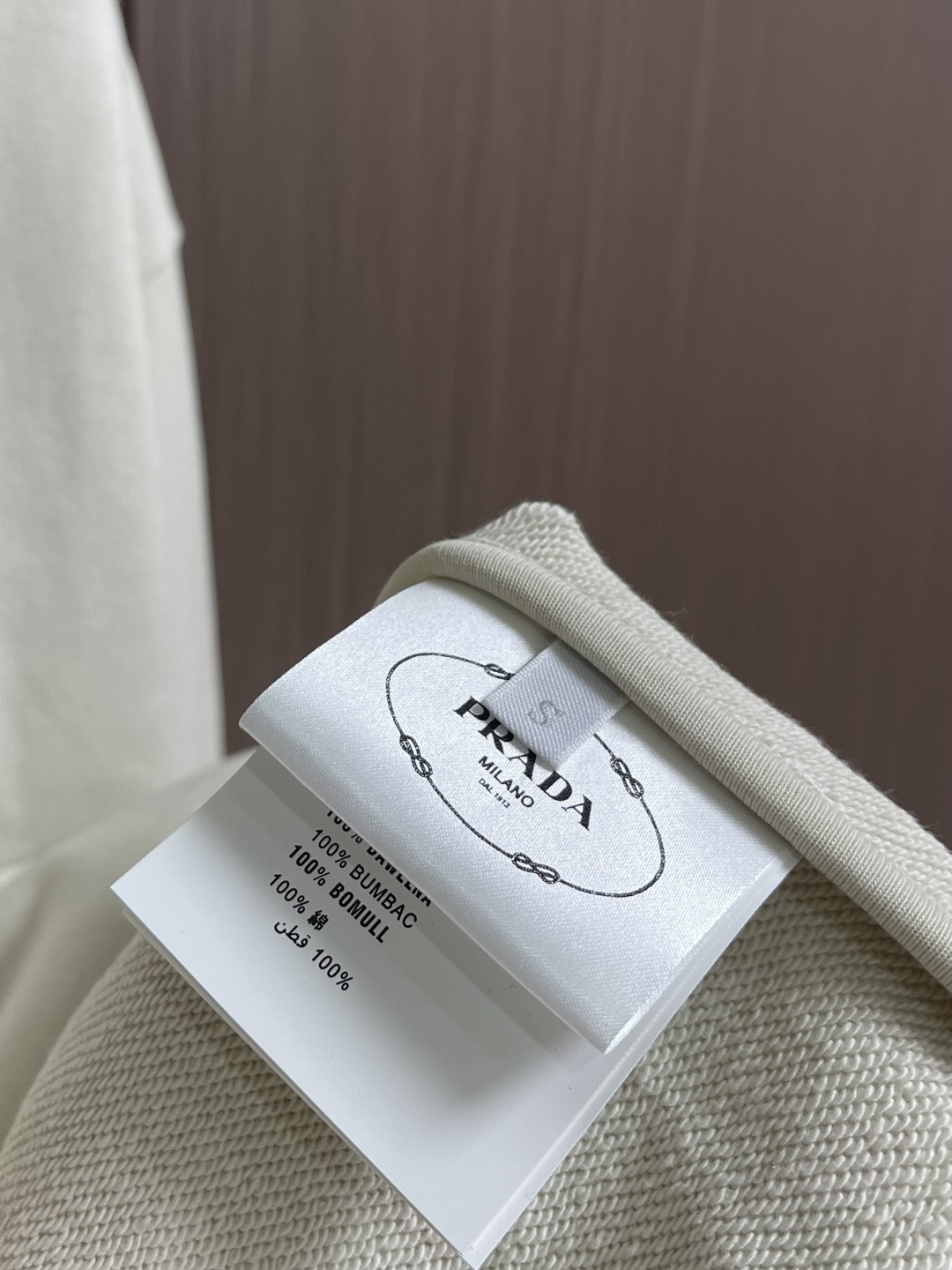 Prada 学院拉链连帽外套，采用32支单纱面＋16支纱底的卫衣面料结构，克重为320gm2；搭配的21