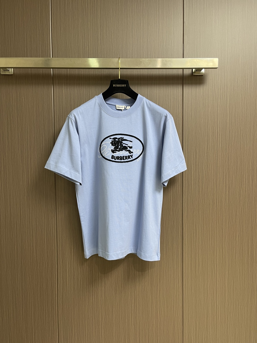 NO:745941,Burberry  The laminated war horse round short-sleeved T-shirt is made of 15-count special-spun compact cotton with a weight of 230gm2. It is matched with 32-count high-weight 1x1 ribs for the neckline and has a weight of 349gm2. The special-spun compact cotton uses compact spinning technology in the spinning process, which effectively reduces the yarn count.  The hairiness makes the fabric structure denser, the surface smoother, and the pilling resistance is better. The weight of the fabric is medium to heavy, ensuring that the T-shirt has good stiffness and drape, and is not easy to collapse and deform. Its high count and high weight characteristics ensure excellent elastic recovery and thickness of the collar.  The feel and deformation resistance are the hallmarks of high-quality T-shirts. The flocking printing process is used, and the step is to fix short fiber fluffs on the pattern area with pre-printed adhesive through static electricity or adhesive. It creates a velvety soft, three-dimensional and slightly lustrous T-shirt.  The unique tactile and visual effect of the logo imitates the texture of traditional fabric labels. The overall wiring is straight and delicate, the fabric is comfortable and soft, and the color is consistent without color difference. It can be matched with the same style to create a fashionable look and control various occasions. Customized accessories, three labels are complete, and the same style for men and women!  Sizes XS-L19860909Burberry 叠章战马圆短袖T恤,采用15支特纺紧密棉,克重为230gm2；搭配32支高克重1x1罗纹用于领口,克重为349gm2.特纺紧密棉在纺纱环节应用了紧密纺技术,有效减少了纱线毛羽,使得面料结构更密实、表面更光洁、抗起球性更佳.面料克重属于中等偏重磅,确保了T恤良好的挺括感和垂坠性,不易软塌变形.其高支高克重特性确保了领型极佳的弹性恢复力、厚实感和抗变形能力,是高品质T恤的标志.采用植绒印花工艺,其步骤是将短小的纤维绒毛通过静电或粘合剂,固定在预先印好粘合剂的图案区域.创造出具有天鹅绒般柔软、立体且带有细微光泽的独特触感和视觉效果的徽标,模仿了传统织物标签的质感.整体走线平直细腻,面料舒适柔软,颜色一致无色差能与同款搭配营造时尚造型,驾驭各种场合,定制辅料,三标齐全,男女同款！尺码XS-L XS码肩宽47.5 胸围104 衣长70  S码肩宽49.0 胸围108 衣长72  M码 肩宽50.5 胸围112衣长74 L码 肩宽52.0 胸围116衣长76,,burberry,T-shirt,tees，t-shirt,,Men's clothing