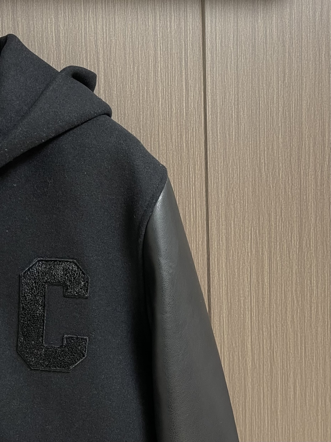 Celine 毛呢皮袖连帽外套，主体采用羊毛混纺面料，经特殊编织工艺打造，质地厚实而不失柔软，呈现细腻的