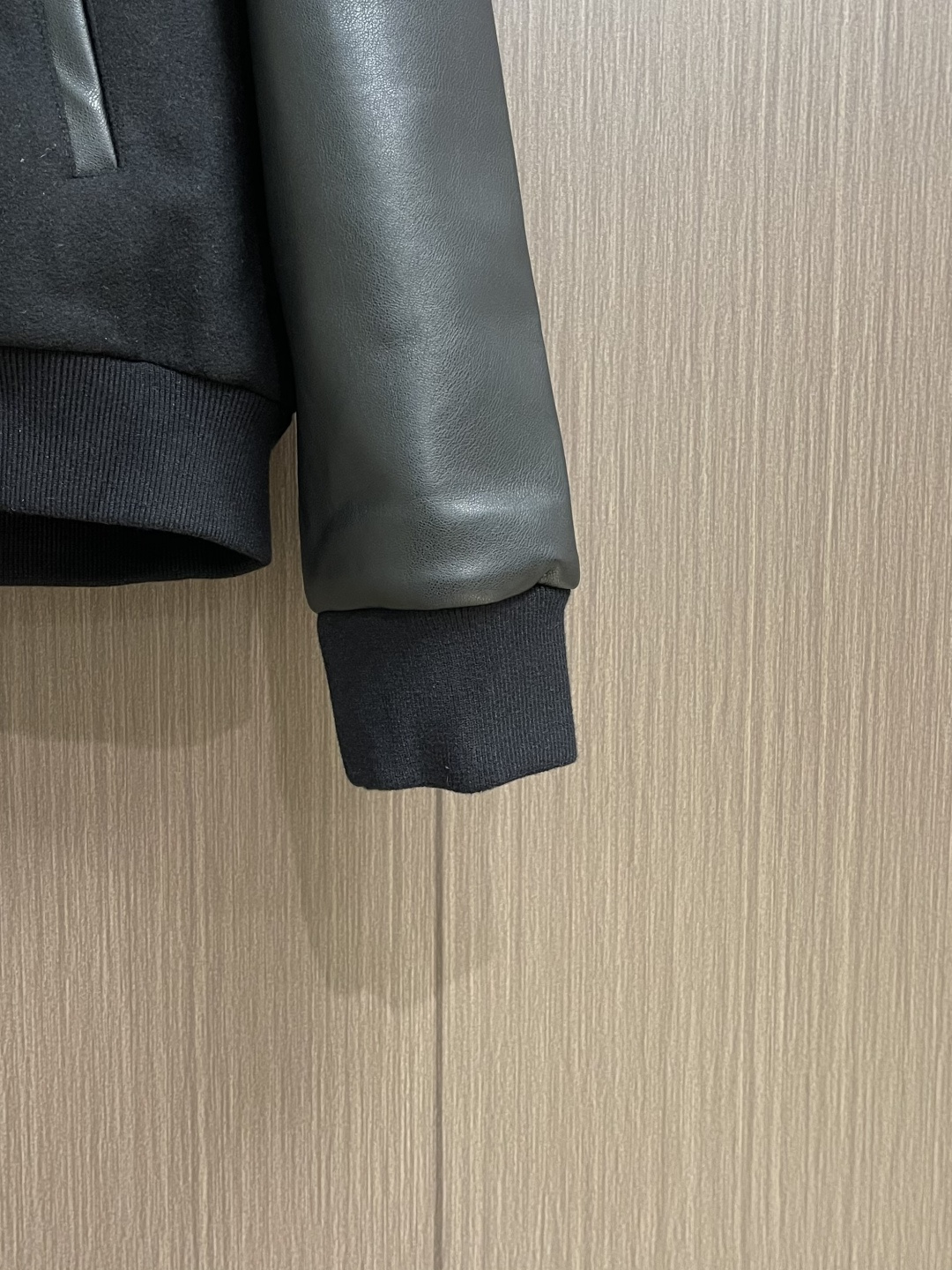Celine 毛呢皮袖连帽外套，主体采用羊毛混纺面料，经特殊编织工艺打造，质地厚实而不失柔软，呈现细腻的