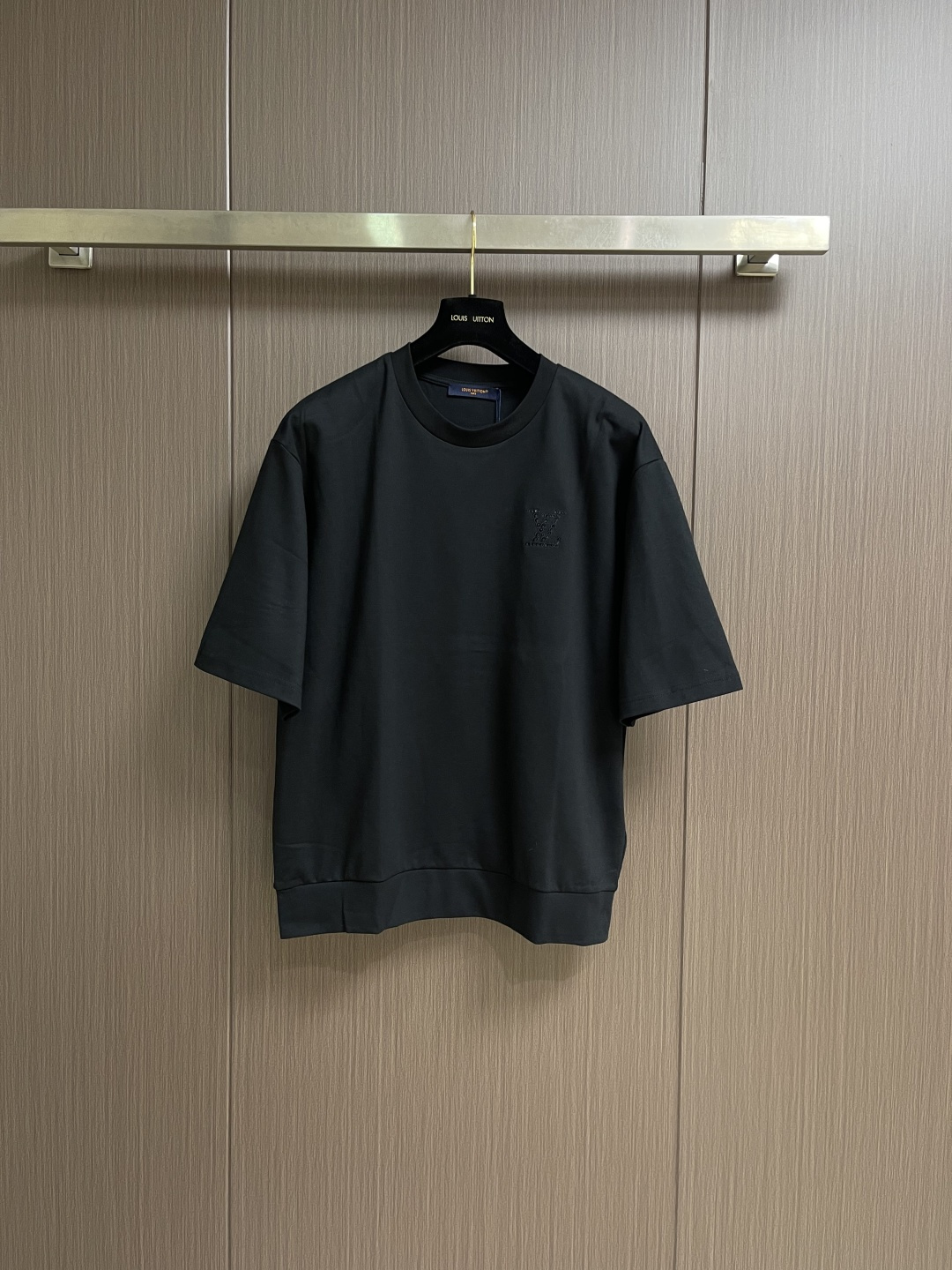 NO:759605,Short sleeve shorts LV  2026ss new summer decorative knitted short-sleeved T-shirt shorts suit. This black mid-sleeve top is made of high-count combed cotton blended fabric. It has been preshrunk and brushed. It feels soft and skin-friendly and has a good drape. It will not change easily after long-term wear.  The shape is pilling. The round neck uses double-strand hemming technology and is matched with ribbing of the same color, which fits the neck line and is not easy to loose. The body is cut with dropped shoulders, and the three-quarter sleeves are designed to modify the arm lines. The hem and cuffs are ribbed with the same fabric.  It is tightened to enhance wearing stability. The brand logo is presented with hollow embroidery technology on the left chest. The stitches are fine and even, three-dimensional and full of exquisite texture. The whole body is combined with flat stitching and seamless gluing technology to reduce seam friction and improve wearing comfort, taking into account both daily leisure and light business scenes. The version is loose and accommodates various body shapes, durable and easy to care for, highlighting a low-key luxury texture. The overall wiring is straight and delicate, the fabric is comfortable and soft, and the color is consistent and has no color difference.  It can be matched with the same style to create a fashionable look, and can be used in various occasions. Customized accessories, complete with three standards, same style for men and women!  ,,louis vuitton,shorts,T-shirt,tees,t-shirt,19860909短袖 短裤 LV 2026ss夏季新款装饰针织短袖T恤短裤套装,这件黑色中袖上衣采用高支精梳棉混纺面料,经预缩与磨毛处理,触感柔软亲肤且具备良好垂坠感,久穿不易变形起球.圆领采用双股线包边工艺,搭配同色系罗纹收边,贴合颈部线条且不易松垮.衣身采用落肩剪裁,七分袖设计修饰手臂线条,下摆与袖口均使用同面料罗纹收束,增强穿着稳定性.左胸位置以镂空刺绣工艺呈现品牌标识,针脚细密均匀,层次立体且富有精致质感.整体采用平车锁边与无痕压胶工艺结合,减少缝线摩擦感,提升穿着舒适度,兼顾日常休闲与轻商务场景,版型宽松包容各种身形,耐穿易打理,彰显低调奢华质感.整体走线平直细腻,面料舒适柔软,颜色一致无色差 能与同款搭配营造时尚造型,驾驭各种场合,定制辅料,三标齐全,男女同款！,,louis vuitton,shorts,T-shirt,tees，t-shirt,,Men's clothing