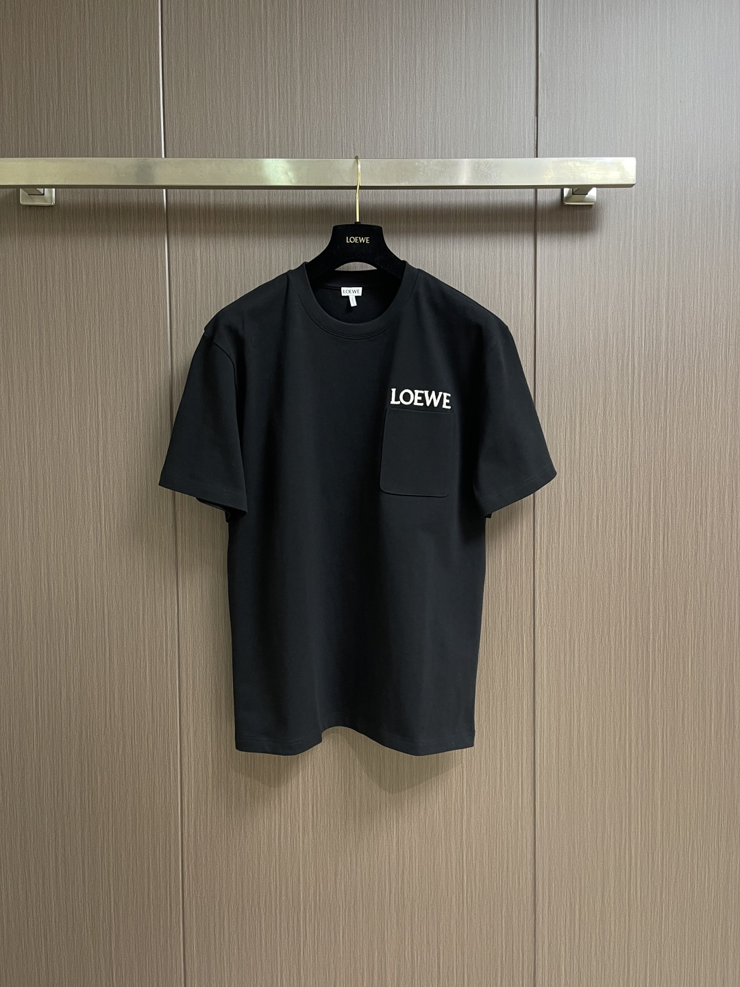 NO:759466,LOEWE  The pocket logo embroidered round neck short-sleeved T-shirt is made of the original pure cotton material. The clothes are thick, crisp, drapey, and not easy to collapse and deform. The double yarn structure makes it more durable and washable, and not easy to deform. It has a delicate touch that is far superior to ordinary cotton T-shirts on the market. The pocket logo embroidery is the core logo of LOEWE. The embroidery process requires extremely high thread materials, stitch density and pattern restoration, and is of high quality.  The key point is that the thread weight of 320g customized threaded cuffs and collar is even higher than that of the main fabric (320g), which ensures the long-term stability of the collar and sleeve shapes and is not easy to loosen after washing. It is custom-woven and dyed, without any color difference from the original version. The ingenious craftsmanship is perfectly restored, three standards are complete, and customized accessories. Sizes S-XL, loewe, T-shirt, tees, t-shirt,19860909LOEWE 口袋logo刺绣圆领短袖T恤,面料采用原版一致纯棉材质,衣服厚实、挺括、有垂感,不易软塌变形.双纱结构使其更耐穿耐洗,不易变形.触感细腻,远超市面普通棉T.口袋logo刺绣LOEWE的核心标识,刺绣工艺对线材、针脚密度和图案还原度要求极高,是品质的关键.320g定制螺纹袖口、领口的螺纹克重甚至比主面料还高（320g),确保了领型和袖型的长期稳定,洗后不易松懈.定织定染,与原版无任何色差.匠心工艺完美还原,三标齐全,定制辅料.尺码S-XL,,loewe,T-shirt,tees，t-shirt,,Men's clothing