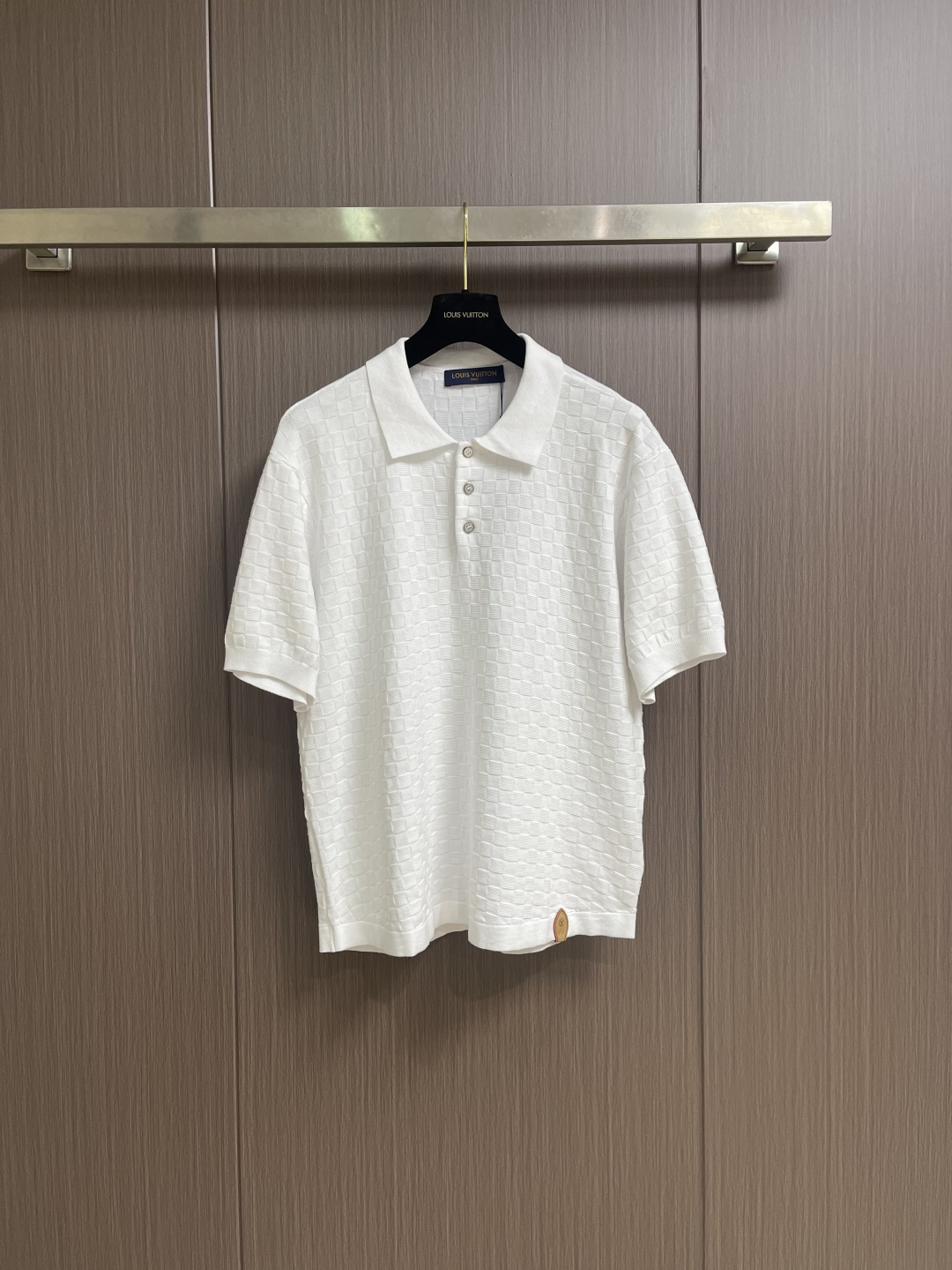 NO:759603,LV  Silk cotton pique leather label Polo shirt. This off-white short-sleeved Polo shirt is made of natural linen blended fabric. It has been treated with a special washing and pre-shrinking process. It combines the breathability and freshness of linen with the softness and skin-friendlyness of cotton. The cloth surface shows a natural fine wrinkle texture.  , with a casual and relaxed texture. The neckline is reinforced with twill fabric lining, and combined with double-strand stitching technology, it is washable, durable and not easily deformed. There are three custom matte metal buttons at the placket, which complement the overall simple style. Slightly dropped shoulders are cut with a loose silhouette.  The shape design not only ensures comfort but also looks casual and neat. The cuffs and hem are all made of the same color thin thread dense copying process. The edges are flat and not easy to fall off. The leather brand logo at the hem is fixed by hot pressing process, which has both recognition and firmness. The back collar is invisible  The stitching process makes the details more exquisite, and the overall craftsmanship perfectly combines the comfort of natural materials with modern minimalist design. It is a quality choice for creating a relaxed look in spring and summer. The overall routing is straight and delicate, the fabric is comfortable and soft, and the colors are consistent without color difference.  It can be matched with the same style to create a fashionable look, and can be used in various occasions. Customized accessories, complete with three standards, same style for men and women!  Size S-XL S size bust 108 shoulder width 43 length 66 medium size bust 112 shoulder width 45 length 68 L size bust 116 shoulder width 47 length 70 XL size bust 120 shoulder width 49 length 72,,louis vuitton,T-shirt,19860909LV 丝棉珠地皮标Polo衫,这款米白色短袖Polo衫采用天然亚麻混纺面料,经特殊水洗预缩工艺处理,兼具亚麻的透气清爽与棉的柔软亲肤,布面呈现自然的细微褶皱肌理,自带随性松弛的质感.领口采用斜纹布内衬加固,配合双股线锁边工艺,耐洗耐穿不易变形,门襟处三颗定制哑光金属纽扣,与整体简约风格相得益彰.微落肩剪裁配合宽松廓形设计,既保证了舒适度又显随性利落,袖口与下摆均采用同色系细线密拷工艺,边缘平整不易脱线,下摆处的皮质品牌标采用热压工艺固定,兼具辨识度与牢固性,后领的隐形缝线处理让细节更显精致,整体工艺将天然材质的舒适感与现代极简设计完美融合,是春夏季节打造松弛感穿搭的品质之选.整体走线平直细腻,面料舒适柔软,颜色一致无色差 能与同款搭配营造时尚造型,驾驭各种场合,定制辅料,三标齐全,男女同款！尺码S-XL S码 胸围108 肩宽43衣长66 M码胸围112肩宽45衣长68 L码 胸围116肩宽47 衣长70 XL码胸围120肩宽49衣长72,,louis vuitton,T-shirt,,Men's clothing