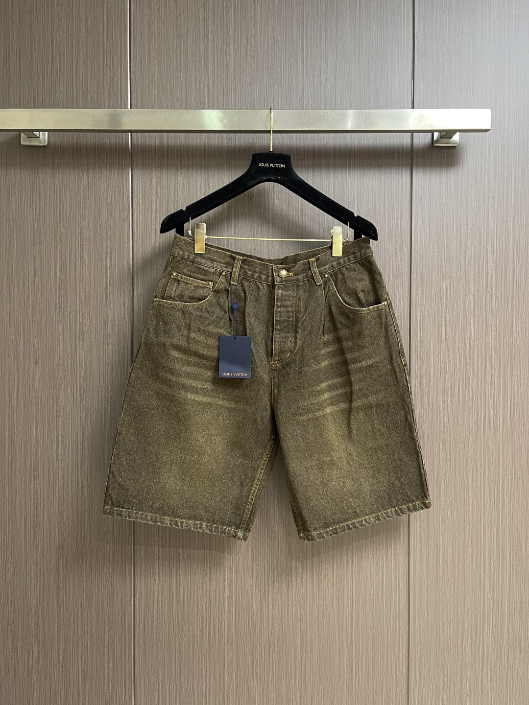 NO:773757,LV  Distressed washed denim shorts with leather label are made of imported heavyweight denim fabric. After multiple distressed washing processes, they present a natural retro tan tone. The fabric is thick and crisp, with excellent wear resistance and breathability. The upper body is comfortable and not sweaty. Perfect  Suitable for spring and summer wear; classic high-waisted straight-leg pants design, with metal buttons and zipper placket at the waist, smooth opening and closing, fitting the waist and abdomen lines, more tolerant to the body, easily modifying the leg shape, creating a casual and relaxed retro style; there are waistbands on both sides.  The typical diagonal pockets are paired with double patch pockets on the back, which combines practicality and style. The back pockets are embellished with the brand's exclusive letter embroidery logo, with fine and neat stitching, low-key highlighting the brand recognition; the trousers are made of bright yellow contrasting topstitching, which is evenly and firmly routed.  Every stitching accurately fits the shape, which not only strengthens the structural stability, but also adds a sense of detail to the overall shape; the back of the waistband is equipped with the brand's exclusive leather label, which has a delicate texture and is hot-printed with the brand logo. The details show the high-end clothing standards. Sizes S-XL  29-30-31-32 The counter sizes are too large. 29 yards, pants length 58, waist 85 hips 105, 30 yards pants length 59, waist 89 hips 109, 31 yards pants length 60, waist 93 hips 113, 32 yards, pants length 61, waist 97 hips 117,, Louis Vuitton, shorts,19860909LV 皮标做旧水洗牛仔短裤,采用进口重磅丹宁牛仔面料,经过多重做旧水洗工艺处理,呈现出自然复古的棕褐色调,面料厚实挺括,兼具出色的耐磨性与透气性,上身舒适不闷汗,完美适配春夏穿搭；经典高腰直筒裤型设计,搭配腰头金属纽扣与拉链门襟,开合顺畅,贴合腰腹线条,对身材包容度更高,轻松修饰腿型,打造随性松弛的复古穿搭氛围；腰头两侧设置经典斜插口袋,搭配后片双贴袋设计,兼具实用性与造型感,后袋点缀品牌专属字母刺绣标识,针脚细密工整,低调彰显品牌辨识度；裤身采用明黄色撞色明线工艺,走线均匀牢固,每一处缝线都精准贴合版型,既强化了结构稳定性,又为整体造型增添了细节层次感；腰头后侧配备品牌专属皮质皮标,质感细腻,烫印品牌标识,细节处尽显高端制衣水准.尺码S-XL 29-30-31-32 专柜码数偏大 29码 裤长58 腰围85臀围105 30码 裤长59 腰围89臀围109 31码裤长60 腰围93臀围113 32码 裤长61腰围97臀围117,,louis vuitton,shorts,,Men's clothing