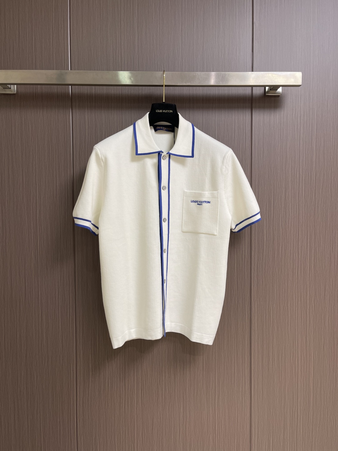 NO:831324,LV  Knitted short-sleeved shirt with color-blocking embroidery of pocket letters. This knitted short-sleeved shirt with color-blocking embroidery of pocket letters is made of high-quality cotton waffle knitted fabric. The three-dimensional honeycomb texture creates a unique three-dimensional texture, which not only gives the clothes a rich texture, but also uses the air layer structure to achieve excellent breathability and moisture wicking performance. It feels soft and skin-friendly, and will not easily deform after long-term wear. The body adopts classic lapel and placket designs, and the collar, cuffs and placket are  It uses blue and white contrasting rib edging technology, with distinct color layers and stable elasticity. The placket is opened and closed with rounded metal buttons, which are smooth and durable; the chest patch pocket is supplemented by exquisite letter embroidery, with neat and dense stitches, a full and three-dimensional embroidery surface, which is strong and washable. The overall version is loose and decent, with both college style and daily wearability. It is an excellent item with both texture and comfort in summer. The overall line is straight and delicate, the fabric is comfortable and soft, and the color is consistent without color difference.  It can be matched with the same style to create a fashionable look, and can be used in various occasions. Customized accessories, complete with three standards, same style for men and women!  Size S-XL S size bust 100 shoulder width 45 length 67 medium size bust 104 shoulder width 47 length 69 L size bust 108 shoulder width 49 length 71 XL size bust 112 shoulder width 51 length 73,,louis vuitton,shirts,T-shirt,19860909LV 口袋字母拼色刺绣针织短袖衬衫,这款口袋字母拼色刺绣针织短袖衬衫,采用高品质全棉华夫格针织面料打造,凭借立体蜂巢纹理构建出独特的三维肌理,既赋予衣物丰盈质感,又借助空气层结构实现卓越透气与吸湿排汗性能,触感软糯亲肤,久穿不易变形.衣身采用经典翻领与门襟设计,领口、袖口及门襟处运用蓝白撞色罗纹镶边工艺,色彩层次分明且弹性稳固.门襟采用圆润金属纽扣开合,顺滑耐用；胸前贴袋处辅以精致字母刺绣,针脚工整密集,绣面饱满立体,牢固耐洗.整体版型宽松得体,兼具学院风情与日常实穿性,是夏季兼具质感与舒适度的上乘单品.整体走线平直细腻,面料舒适柔软,颜色一致无色差 能与同款搭配营造时尚造型,驾驭各种场合,定制辅料,三标齐全,男女同款！尺码S-XL S码 胸围100 肩宽45衣长67 M码胸围104 肩宽47 衣长69 L码 胸围108 肩宽49 衣长71 XL码胸围112肩宽51 衣长73,,louis vuitton,shirts,T-shirt,,Men's clothing