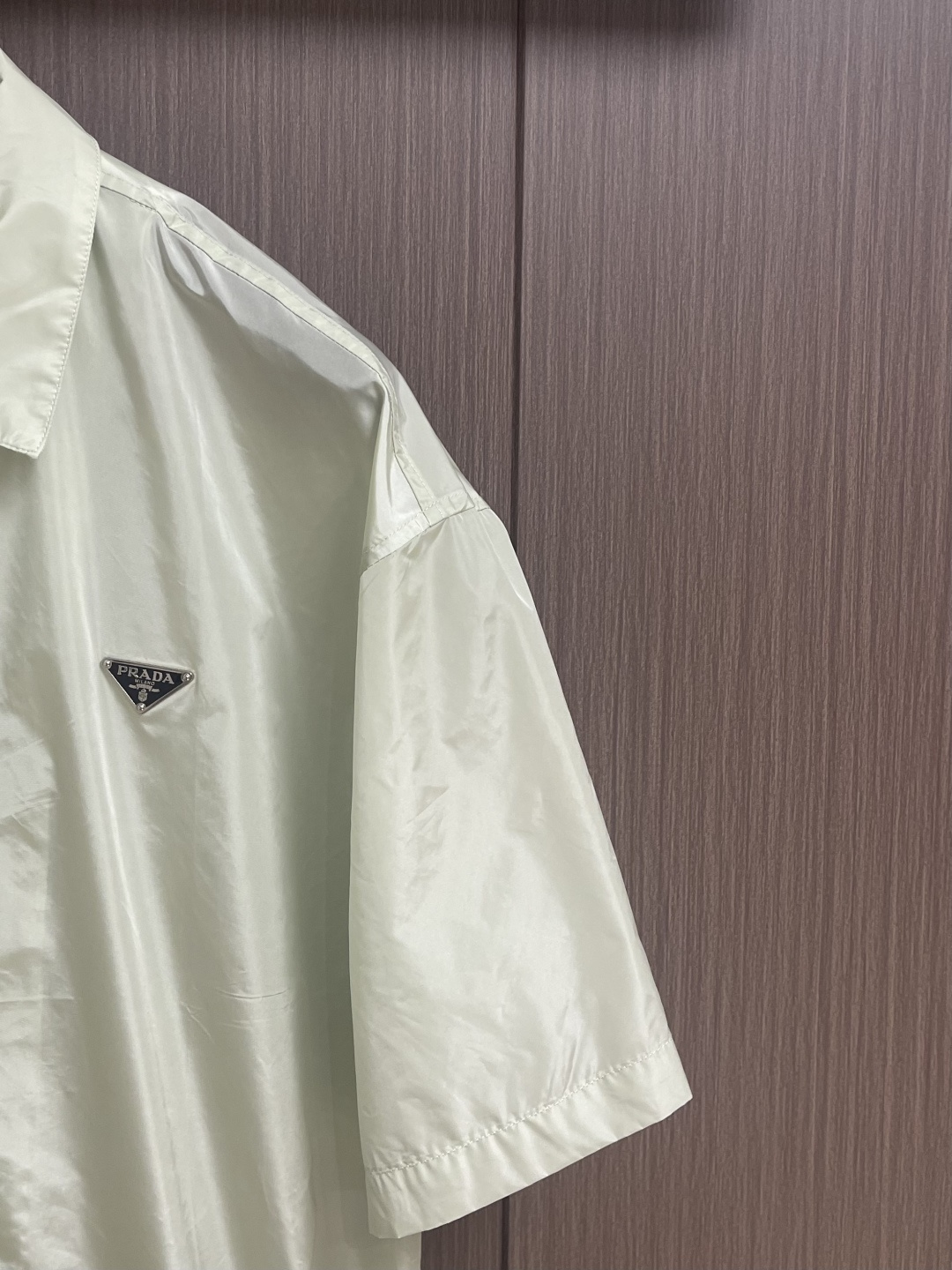 PRADA 三角标识拉链短袖衬衫，穿在身上又舒服又透气，夏天穿也不会觉得闷，而且还有点挺括劲儿，穿上身不