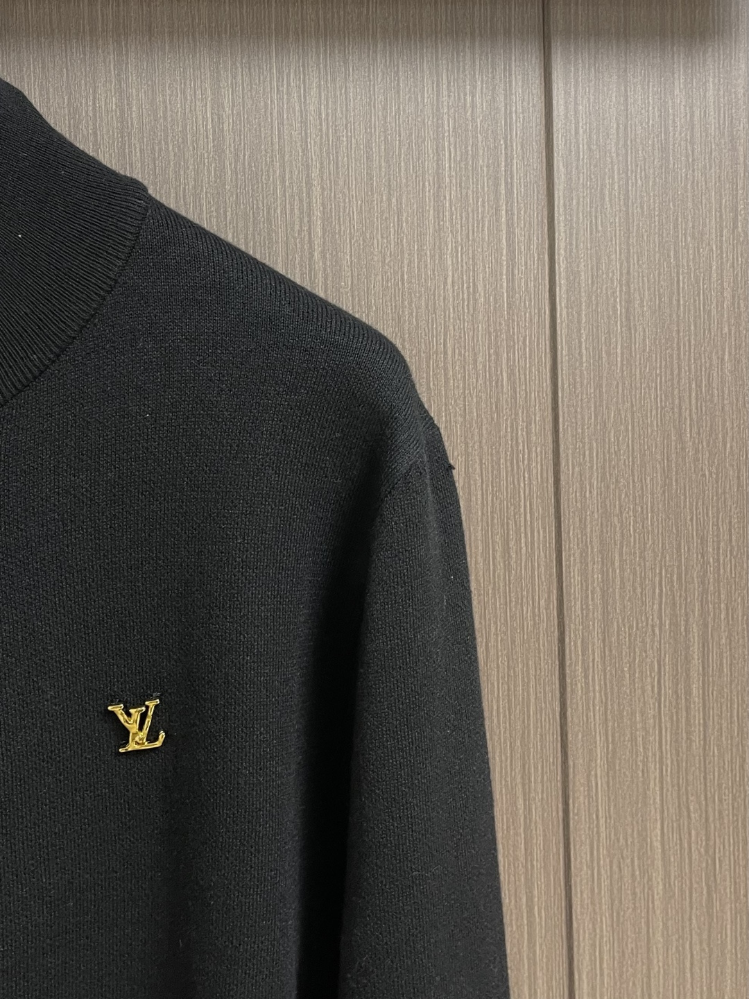 LV 字母标识针织立领夹克外套，这款黑色高领拉链采用重磅细腻的羊毛混纺针织面料，兼具挺括质感与亲肤保暖性