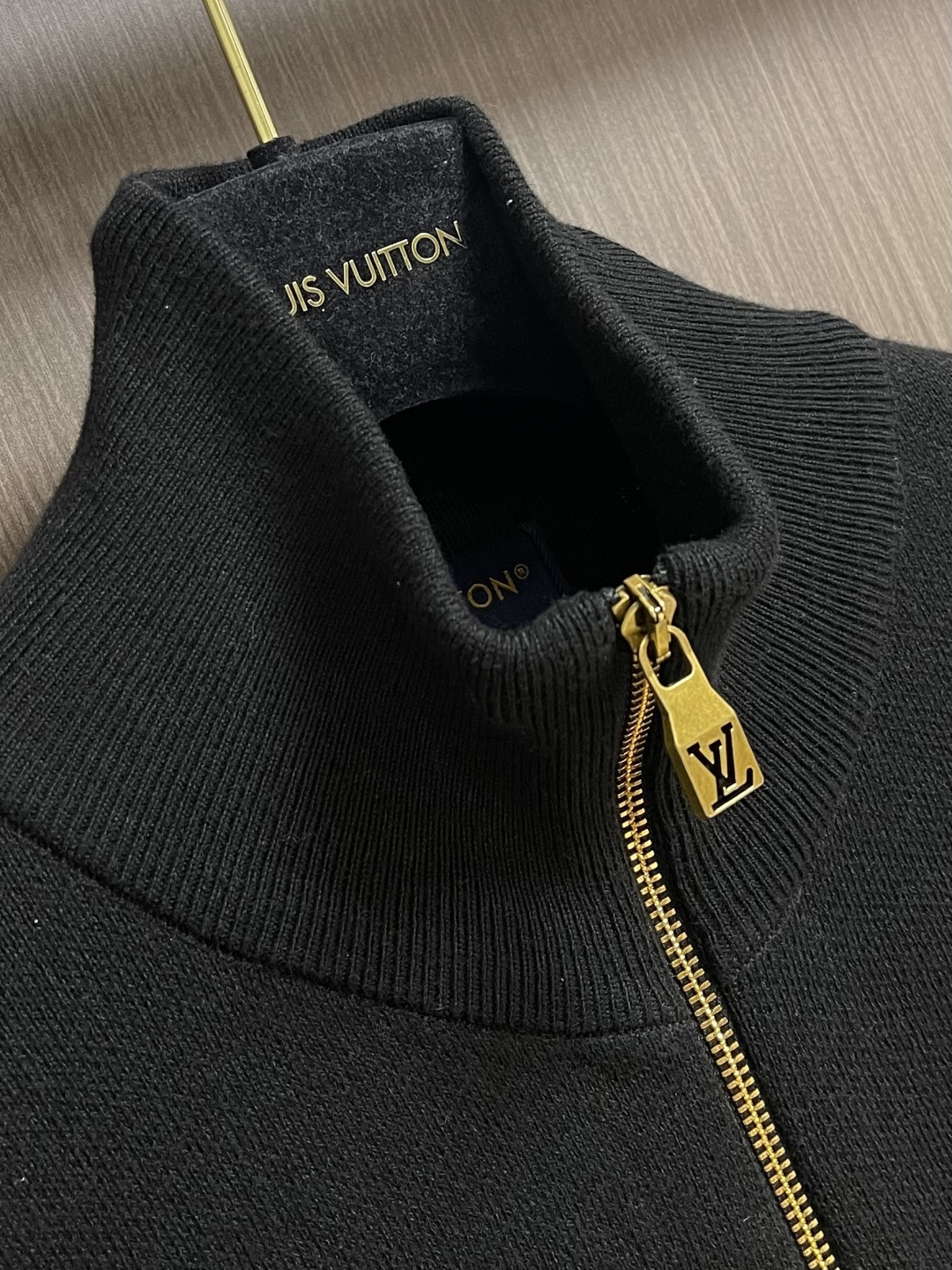 LV 字母标识针织立领夹克外套，这款黑色高领拉链采用重磅细腻的羊毛混纺针织面料，兼具挺括质感与亲肤保暖性