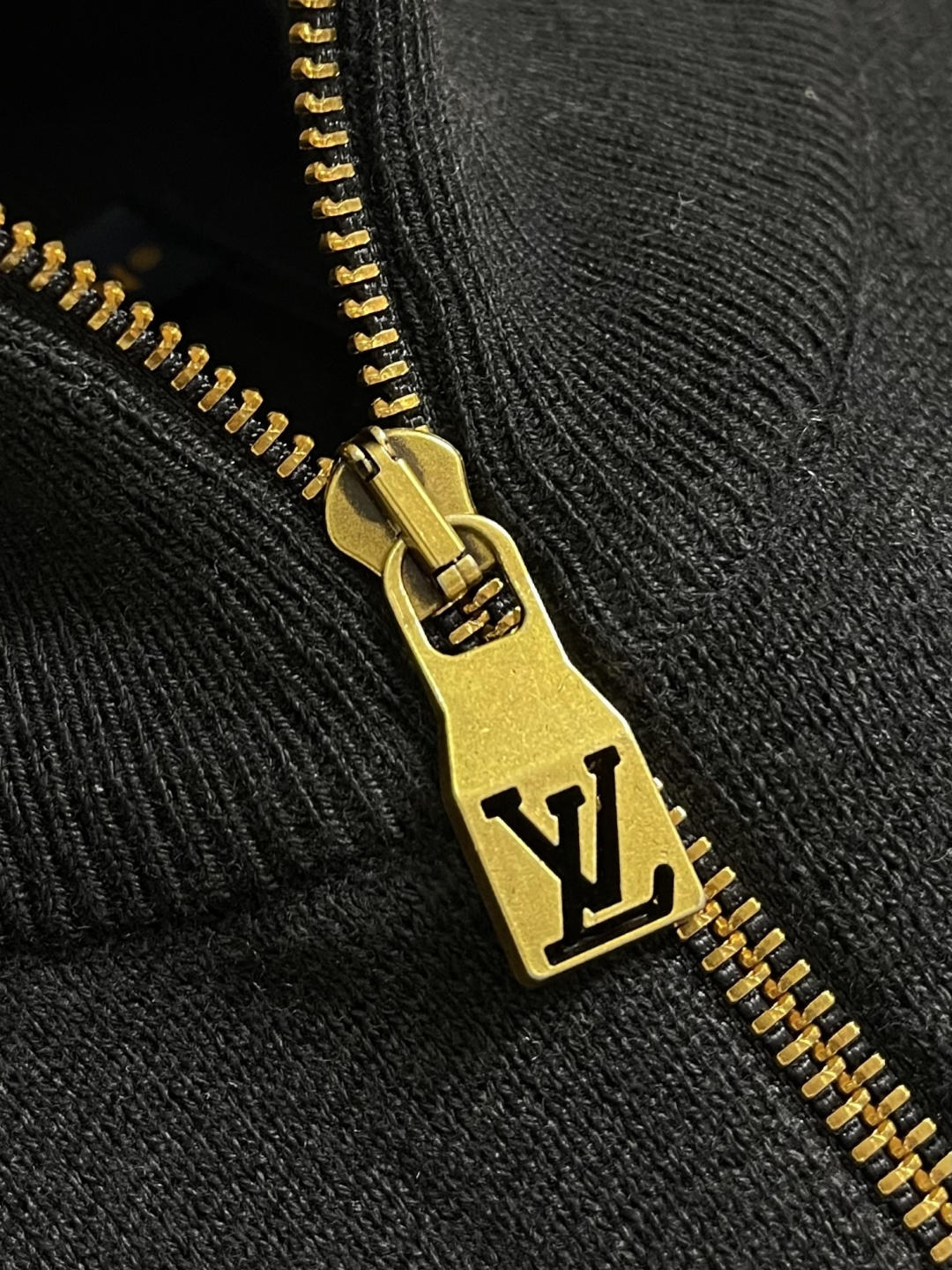 LV 字母标识针织立领夹克外套，这款黑色高领拉链采用重磅细腻的羊毛混纺针织面料，兼具挺括质感与亲肤保暖性