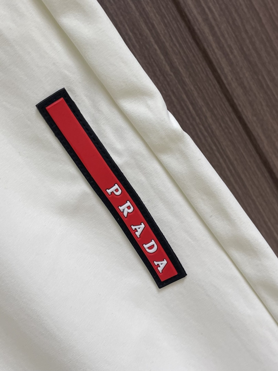 Prada 三角标户外机能风黑白休闲裤，经典倒三角金属标+立体刺绣Logo双重加持，后腰口袋的三角铭牌是