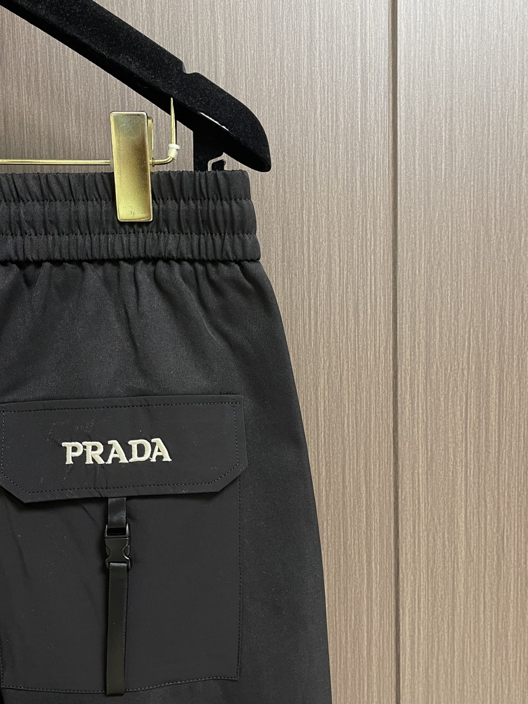 Prada 三角标户外机能风黑白休闲裤，经典倒三角金属标+立体刺绣Logo双重加持，后腰口袋的三角铭牌是