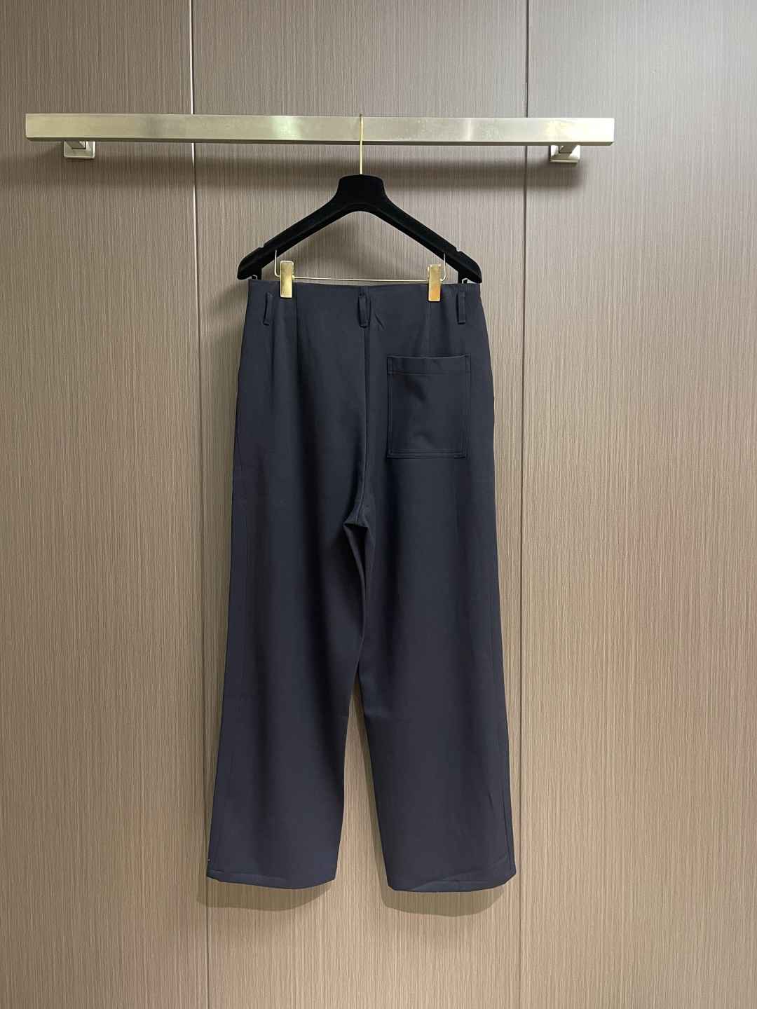 Loewe 皮牌休闲裤，定制丝光雾面羊毛，以雾感深海军蓝为主色调，腰头正面饰有LOE 压纹皮革贴片，与纽